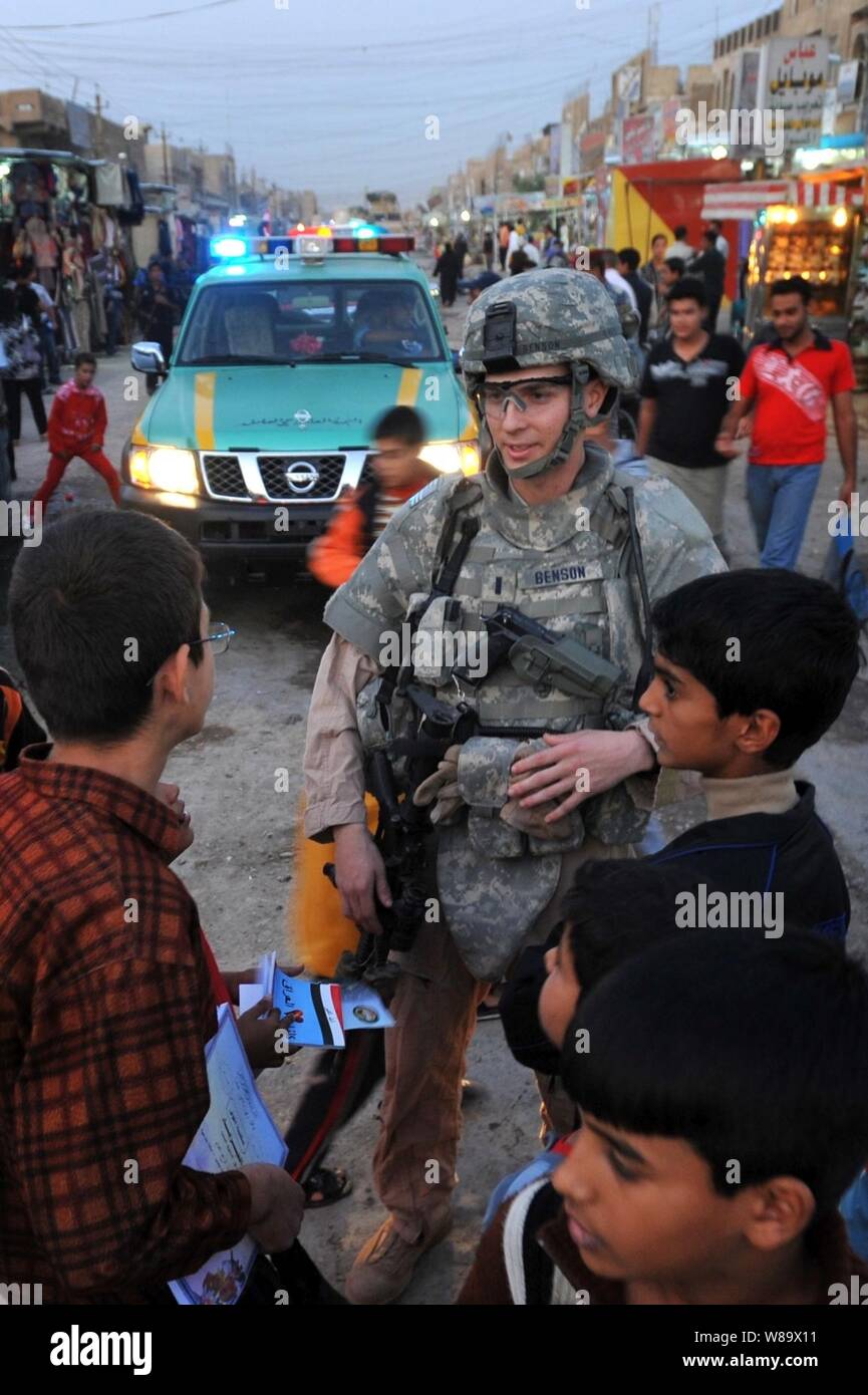 U.S. Air Force 1st Lt. Steven Benson speaks with Iraqi children during a patrol with Iraqi police in the Shurta Market of the Al-Bayaa district of Baghdad, Iraq, on Nov. 14, 2008.  The airmen are assigned to Detachment 3, 732nd Expeditionary Security Forces Squadron and are attached to the 1st Brigade Combat Team, 4th Infantry Division. Stock Photo