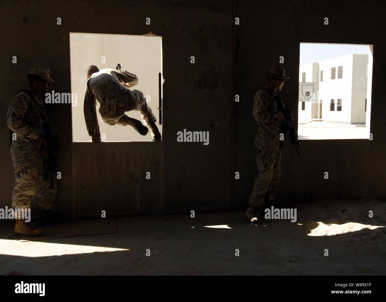 U.S. Marine Corps Lance Cpls. Travis Beckford (left) and Kyle Nance and Cpl. Ryan Burke (right), all from the 4th Platoon, Fleet Anti-terrorism Security Team, advance through buildings during a bilateral urban assault training in Sheik Isa, Bahrain, on Nov. 20, 2008. The Marines are deployed to the U.S. Navy 5th fleet area of operations in support of maritime security operations. Stock Photo