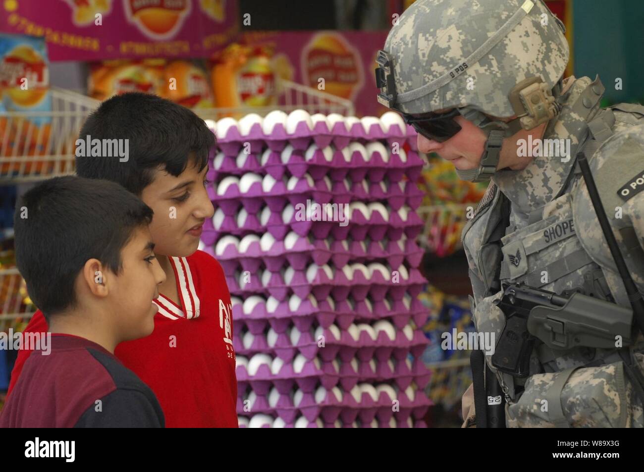 U.S. Air Force Staff Sgt. Kane Shope speaks with Iraqi children in a market during a walking patrol in the Rashid community of southern Baghdad, Iraq, on Dec. 4, 2008.  Shope is assigned to Detachment 3, 732nd Expeditionary Security Forces Squadron attached to 1st Brigade Combat Team, 4th Infantry Division. Stock Photo