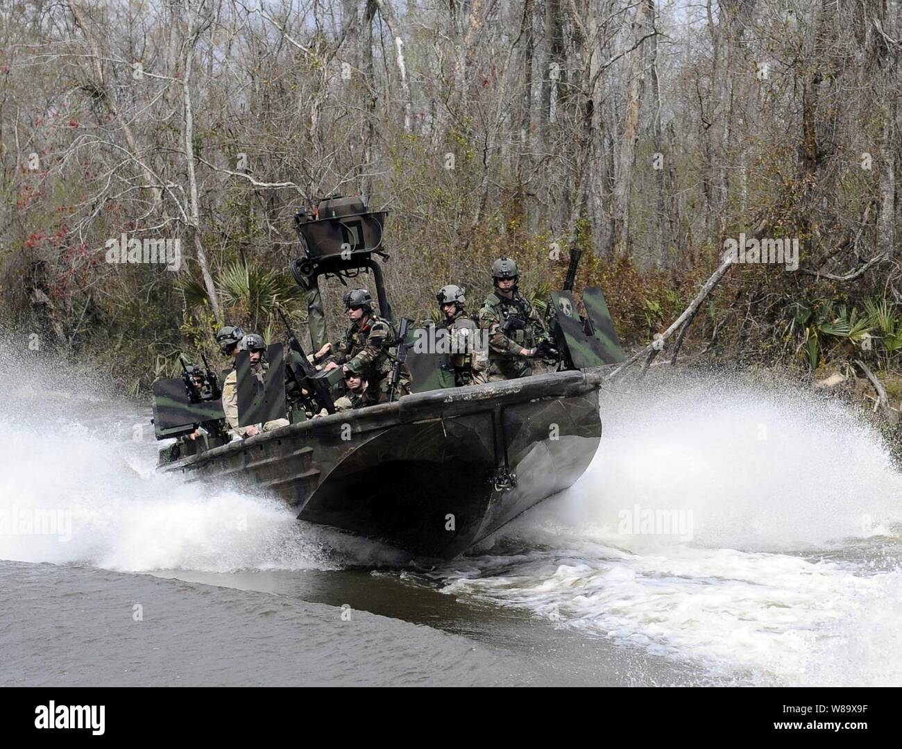 U.S. Navy Special Warfare Combatant-craft crewmen assigned to Special Boat Team 22 conduct live-fire drills on the riverine training range at the John C. Stennis Space Center in Mississippi on March 4, 2009.  Sailors assigned to Special Boat Team 22 operate special operations riverine craft and are assigned to Naval Special Warfare Group 4, the only U.S. special operations command dedicated to operating in riverine environments. Stock Photo