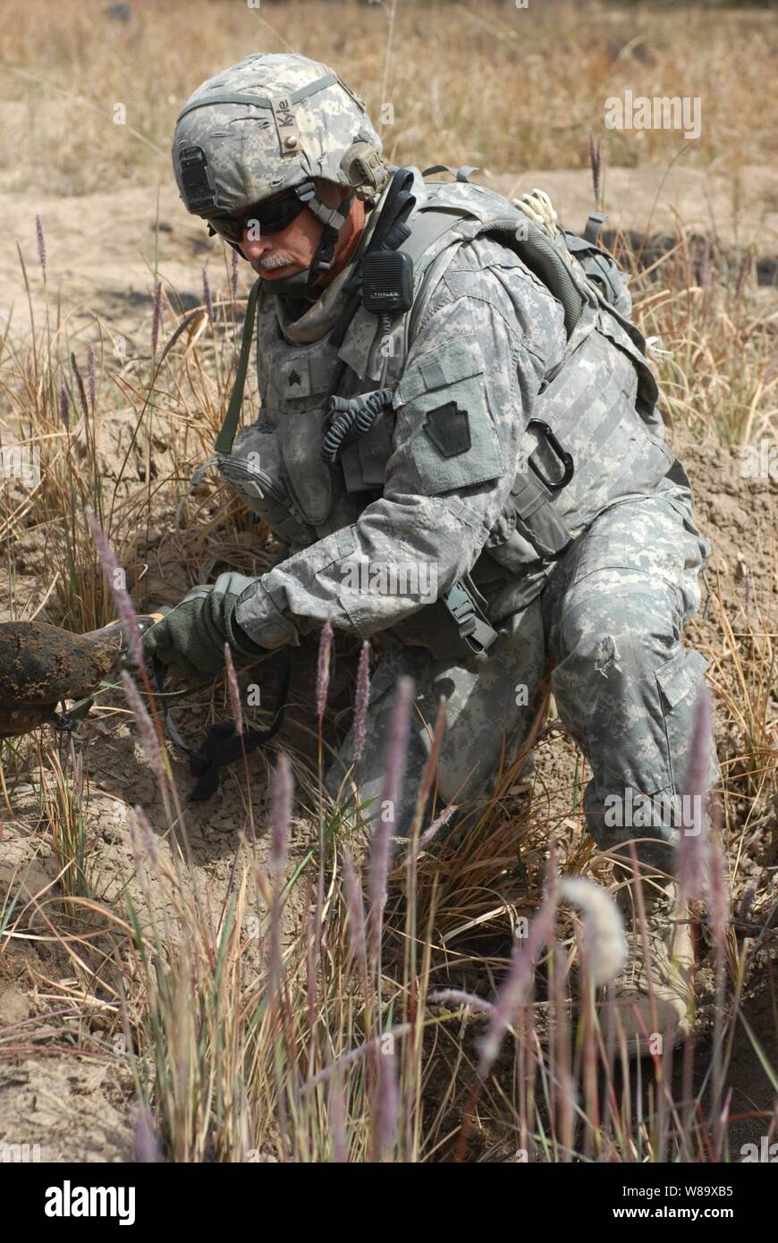 U.S. Army Sgt. Timothy Kyle from the 2nd Brigade Combat Team, 1st Infantry Division digs in a site of possible weapons caches in the city of Abu Ghraib, Iraq, on March 21, 2009. Stock Photo