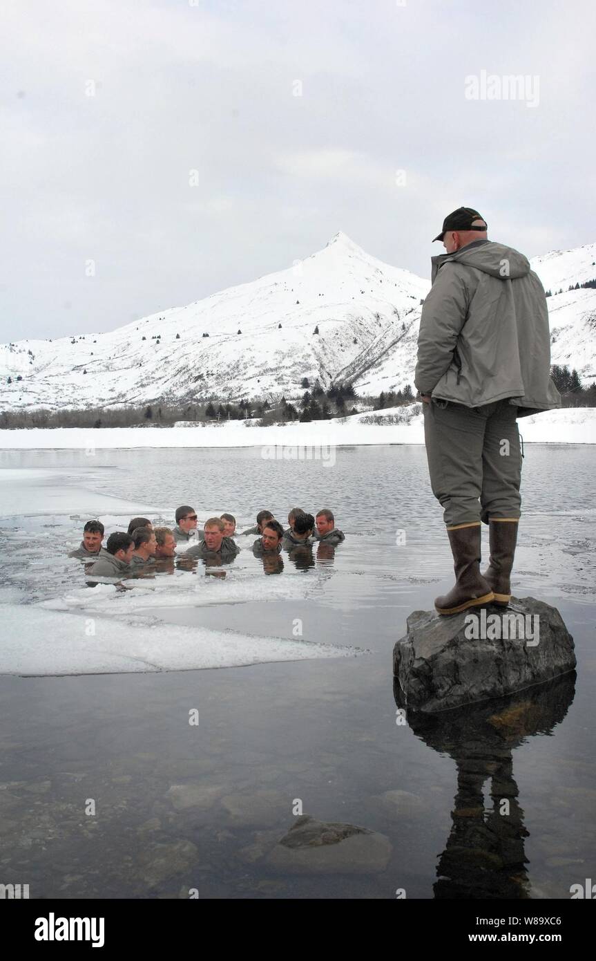 A cold-weather training instructor monitors U.S. Navy sailors as they spend five minutes in near-freezing water as part of SEAL Qualification Training at Kodiak, Alaska, on April 8, 2009.  Candidates are completing the rewarming exercise after spending 48 hours in the Alaskan mountains navigating the rugged terrain and surviving frigid conditions.  The 28-day cold-weather course is part of the year long process to become a Navy SEAL. Stock Photo