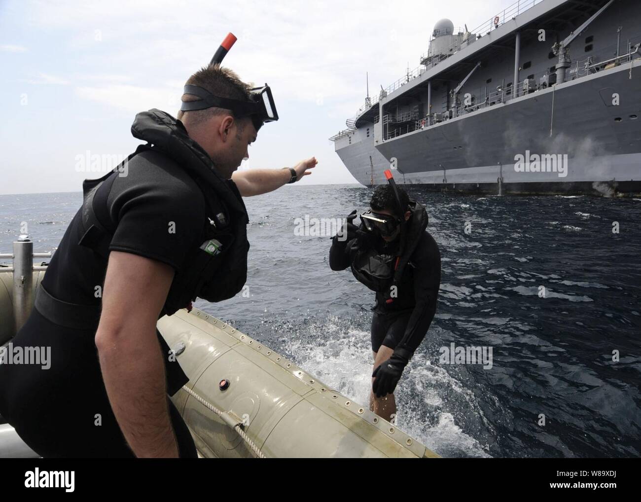 U.S. Navy Petty Officer 2nd Class Kevin Abney instructs newly qualified search and rescue swimmer Seaman Julian Fuenzalida in various dive procedures used aboard the amphibious command ship USS Blue Ridge (LCC 19) in the Pacific Ocean on May 19, 2009. Search and rescue swimmers rescue personnel in distress or danger at sea or on land. Stock Photo