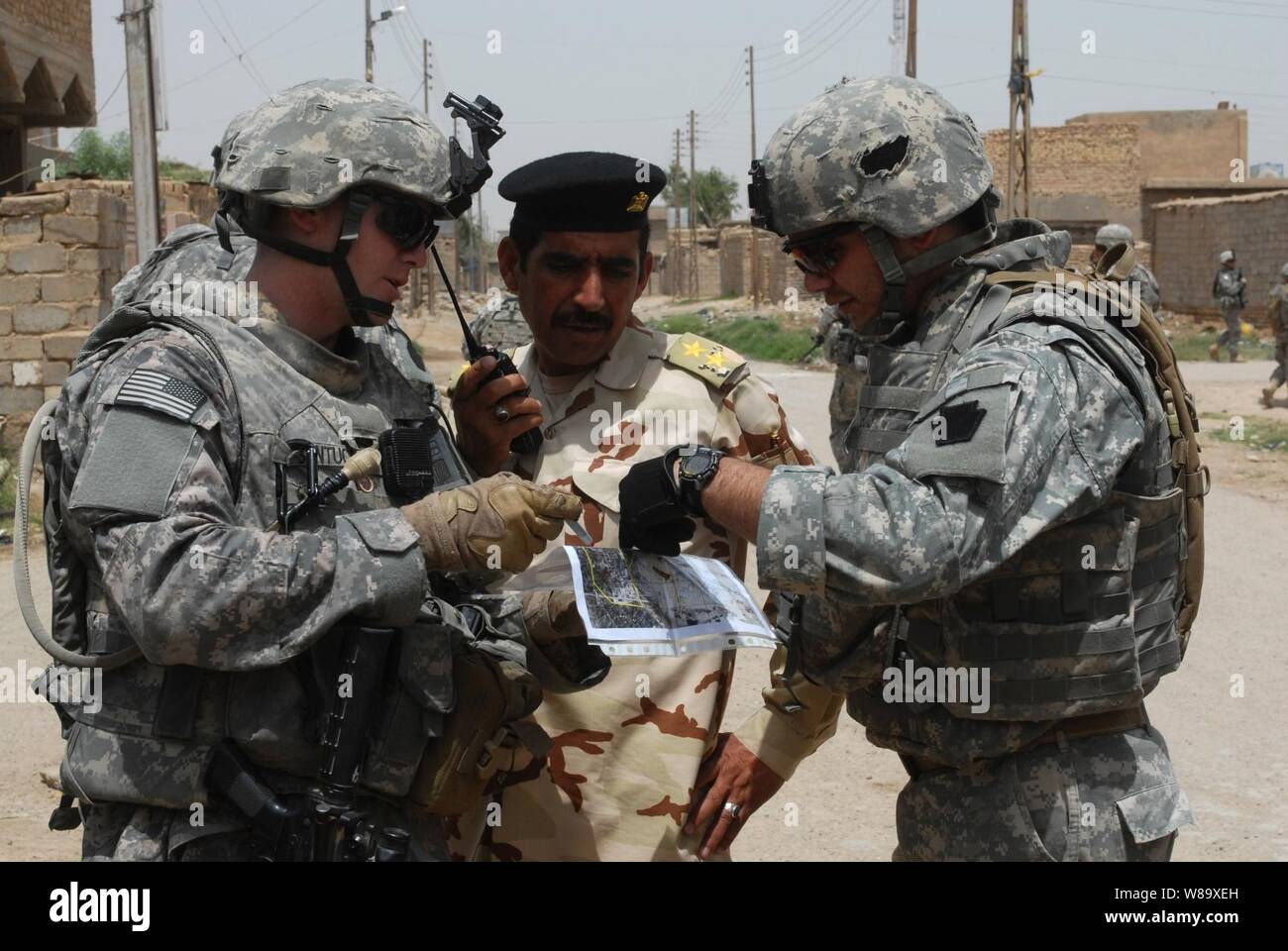 U.S. Army 1st Lt. Fredrick Santucci, attached to 2nd Brigade, 1st Infantry Division, and an Iraqi army officer plan a patrol route through the city of Abu Ghraib, Nassir Wa Salam province, Iraq, on May 17, 2009. Stock Photo
