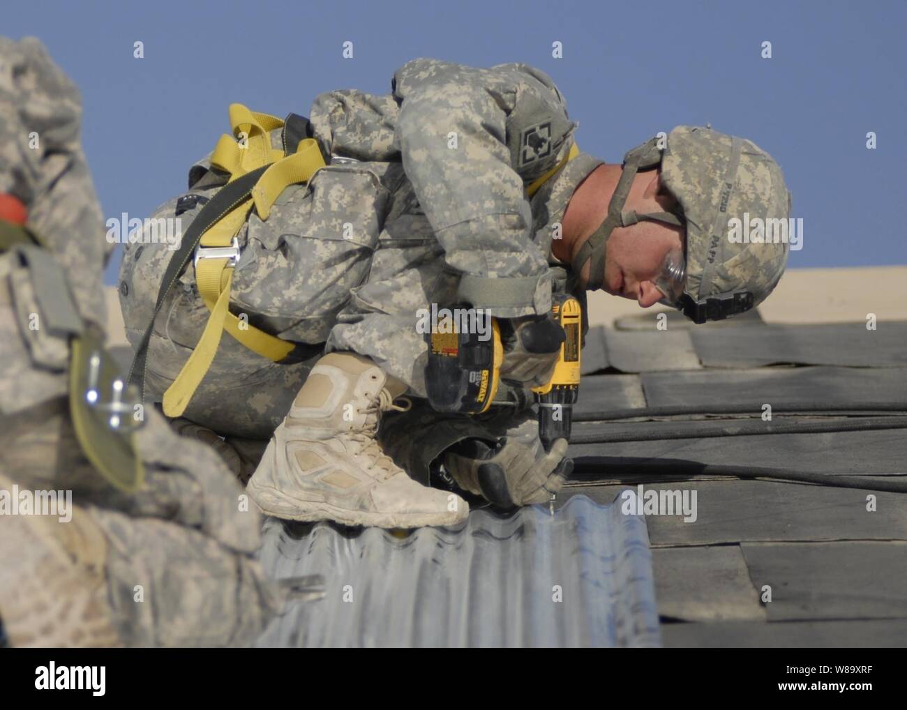 U.S. Army Pfc. Michael Papp, assigned to the 19th Engineer Battalion, installs tin sheets on a roof during a construction project at Kandahar Airfield, Afghanistan, on Sept. 14, 2009.  The 19th Engineer Battalion is forward-deployed to southern Afghanistan in support of Operation Enduring Freedom. Stock Photo