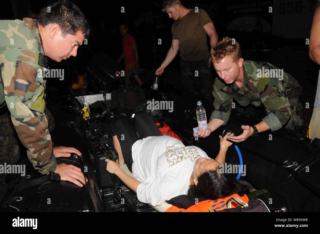 Medical personnel assigned to Joint Special Operations Task Force - Philippines assist a woman in labor during relief efforts in Manila, Philippines, following flooding that destroyed homes and displaced thousands of people in the area on Sept. 27, 2009.  U.S. sailors delivered medical supplies and food and rescued more than 52 people in Manila. Stock Photo