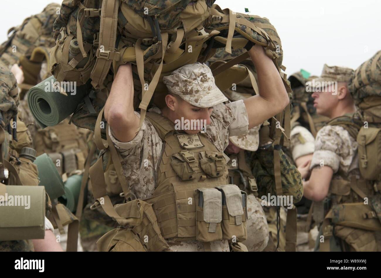 U.S. Marine Corps Lance Cpl. Brandon Focer heaves his pack over his head as he prepares to board a landing craft utility to embark aboard the amphibious assault ship USS Nassau (LHA 4) in Radio Island, N.C., on Oct. 27, 2009.  Focer is assigned to Charlie Company, 2nd Platoon, 24th Marine Expeditionary Unit.  The Nassau and 24th Marine Expeditionary Unit are participating in a composite unit training exercise designed to provide realistic training environments for U.S. naval forces that closely replicate the operational challenges routinely encountered during military operations worldwide. Stock Photo