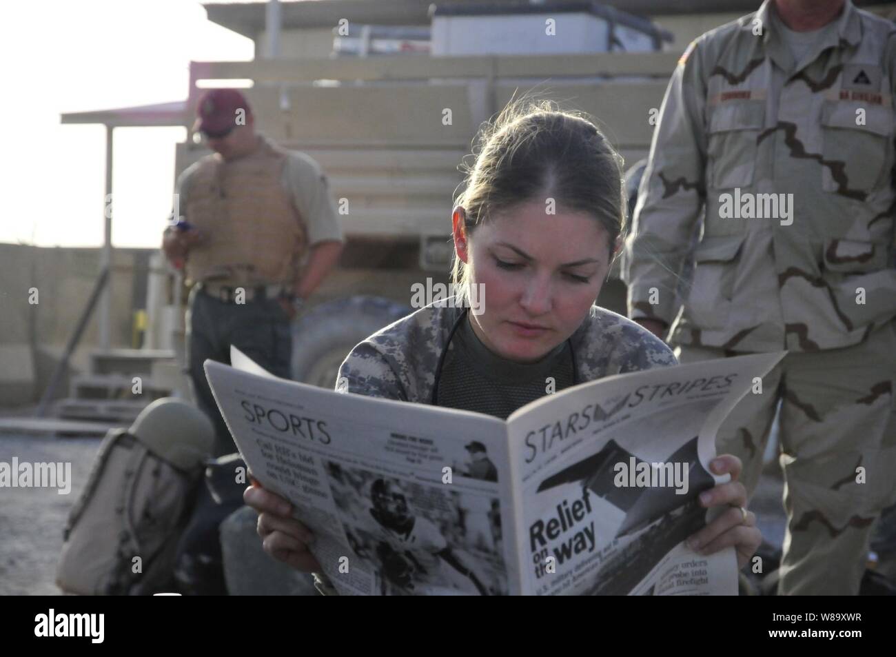 U.S. Army 1st Lt. Tracy Tyson, assigned to the 5th Brigade, 2nd Infantry Division, reads a newspaper at Kandahar Airfield, Afghanistan, while waiting for a flight to Forward Observation Base Wolverine on Oct. 5, 2009. Stock Photo