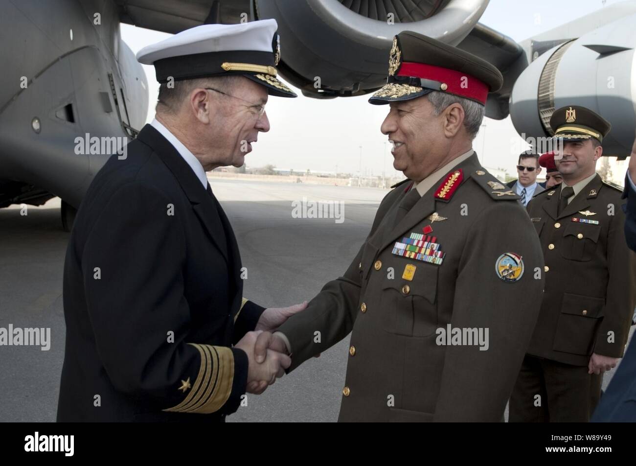 Chairman of the Joint Chiefs of Staff Adm. Mike Mullen, U.S. Navy, is greeted by Egyptian Maj. Gen. Hassan Roweny after his arrival in Cairo, Egypt, on Feb. 13, 2010.  Mullen is on a weeklong tour of the region visiting with key partners and allies. Stock Photo