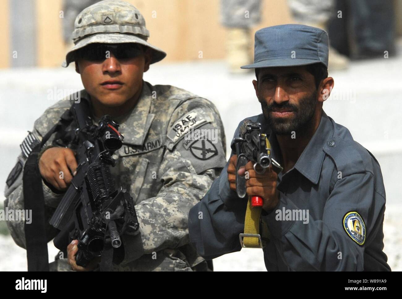U.S. Army Pfc. Alejandro Orona assists Afghan National Police during training at the Afghan police headquarters in Charreh Dera, Afghanistan, on Aug. 28, 2010.  Orona is from 1st Battalion, 87th Infantry Regiment, 1st Brigade Combat Team, 10th Mountain Division. Stock Photo