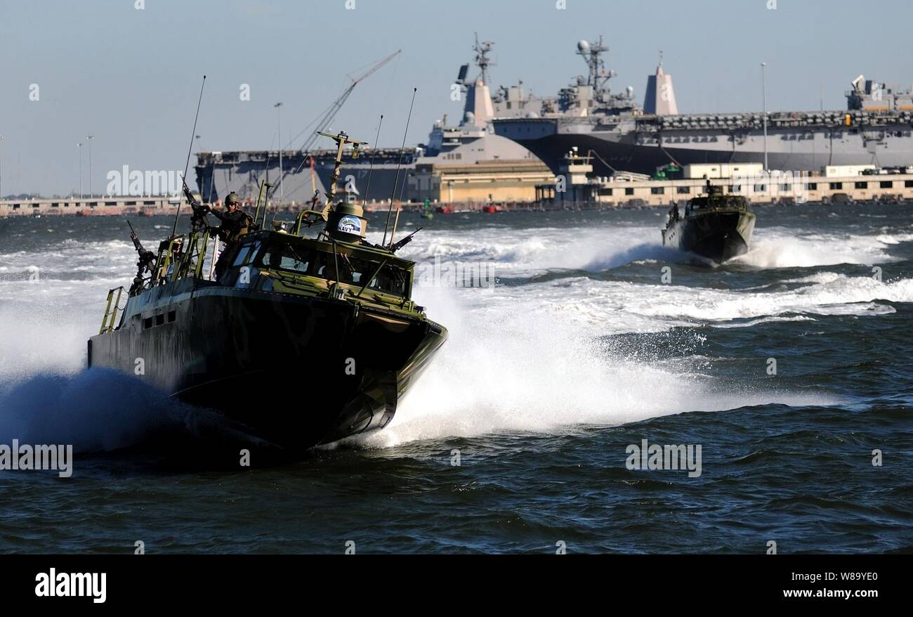 U.S. Navy sailors with Riverine Group 1 conduct maneuvers aboard a Riverine Command Boat (Experimental) (RCB-X) during an alternative fuels demonstration at Naval Station Norfolk, Va., on Oct. 22, 2010.  The RCB-X boat was powered by an alternative fuel blend of 50 percent algae-based and 50 percent fuel oil to support the Secretary of the Navy's efforts to reduce total energy consumption on naval ships. Stock Photo