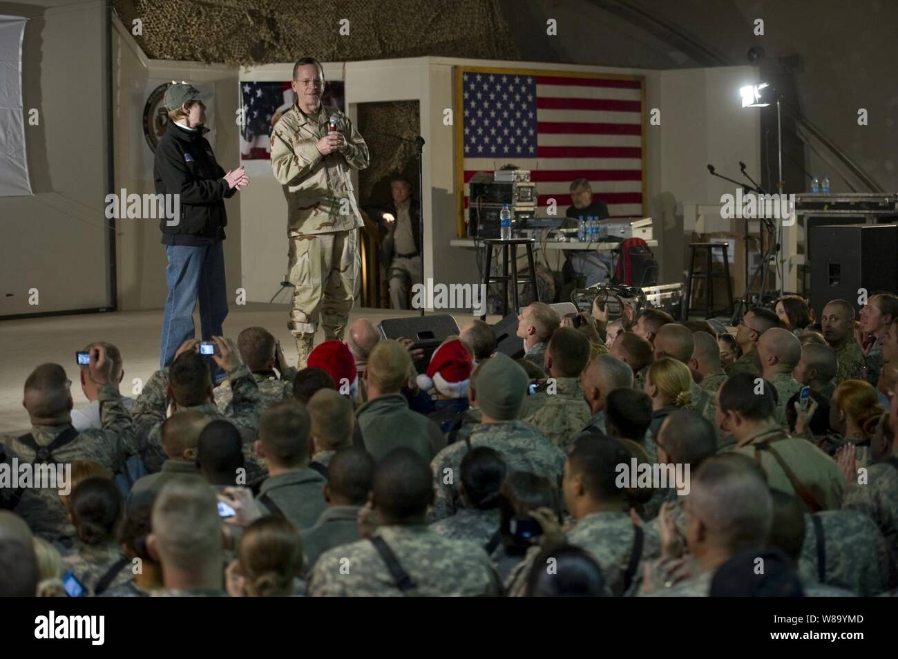 Chairman of the Joint Chiefs of Staff Adm. Mike Mullen, U.S. Navy, and his wife Deborah introduce the performers during the USO Holiday Show at Bagram Air Field, Afghanistan, on Dec.15, 2010.  The Mullens are hosting the tour featuring comedians Robin Williams, Lewis Black and Kathleen Madigan, Tour de France champion Lance Armstrong and country musicians Kix Brooks and Bob Dipiero touring the Central Command area of responsibility. Stock Photo