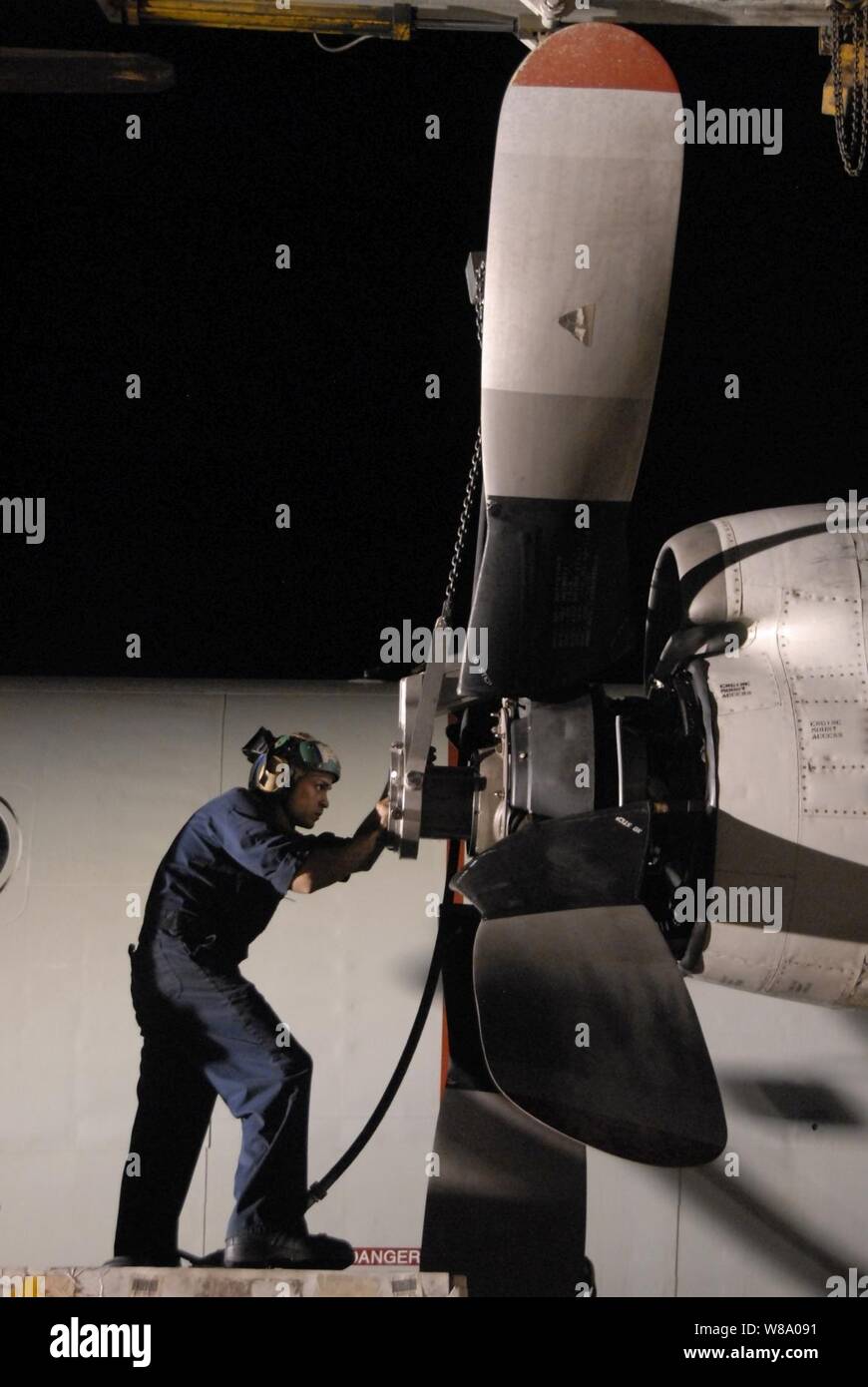 Petty Officer 2nd Class Omar Viraclass, assigned to Patrol Squadron 45, installs a propeller on the number two engine of a P-3C Orion aircraft in Sigonella, Sicily, on June 20, 2011.  Patrol Squadron 45 is deployed to Sicily supporting Operation Unified Protector. Stock Photo