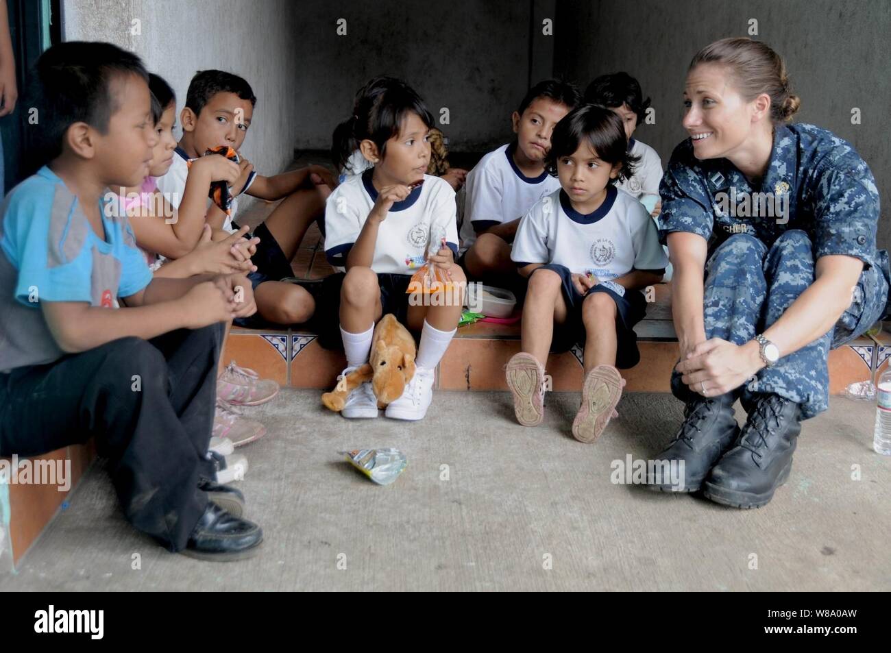 U.S. Navy Lt. Audrey Koecher (right), the judge staff advocate for Continuing Promise 2011, talks with children during a community relations event at Escuela Republica de Japon in Puerto San Jose, Guatemala, on July 8, 2011.  Continuing Promise is a regularly scheduled mission to countries in Central and South America and the Caribbean, where the U.S. Navy and its partnering nations work with host nations and a variety of governmental and nongovernmental agencies to train in civil-military operations. Stock Photo