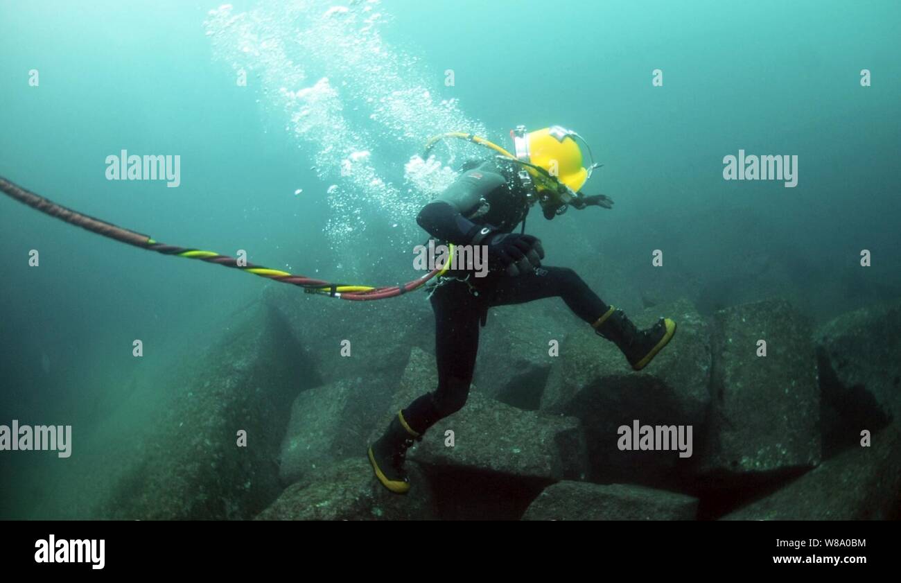 Petty Officer 3rd Class Bryan Myers, assigned to Mobile Diving and Salvage Unit 2, leaps from rock to rock along the ocean floor during diving operations in Valparaiso, Chile, on June 29, 2011.  Mobile Diving and Salvage Unit 2 is participating in Navy Diver-Southern Partnership Station, a multinational partnership engagement intended to increase interoperability and partner nation capacity through diving operations. Stock Photo