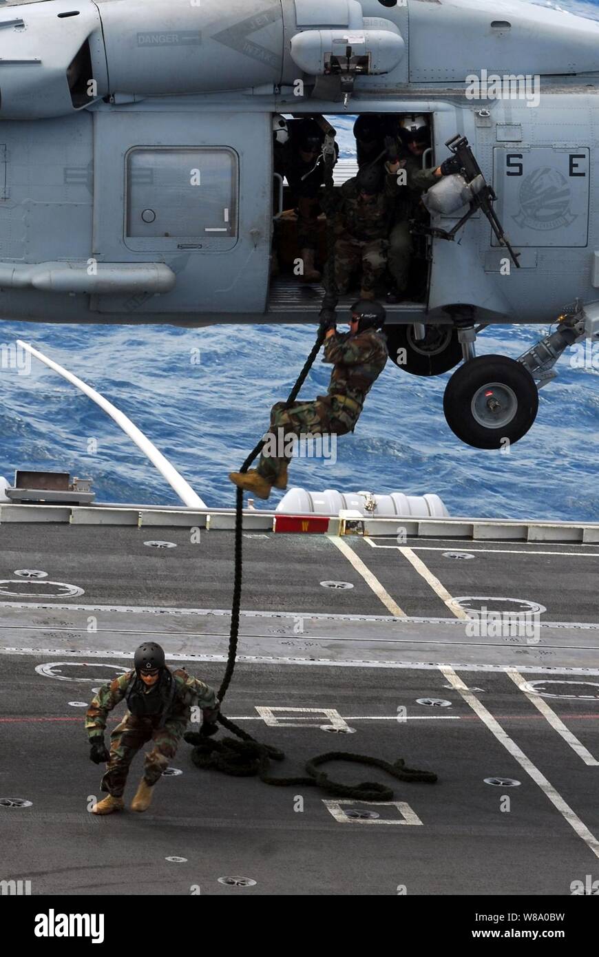 Sailors assigned to Explosive Ordnance Disposal Mobile Unit 5 participate in a fast rope exercise aboard the aircraft carrier USS George Washington (CVN 73) underway in the Indian Ocean on July 7, 2011.  The George Washington began its latest patrol on June 12, departing its forward-operating base at Commander, Fleet Activities Yokosuka. Stock Photo