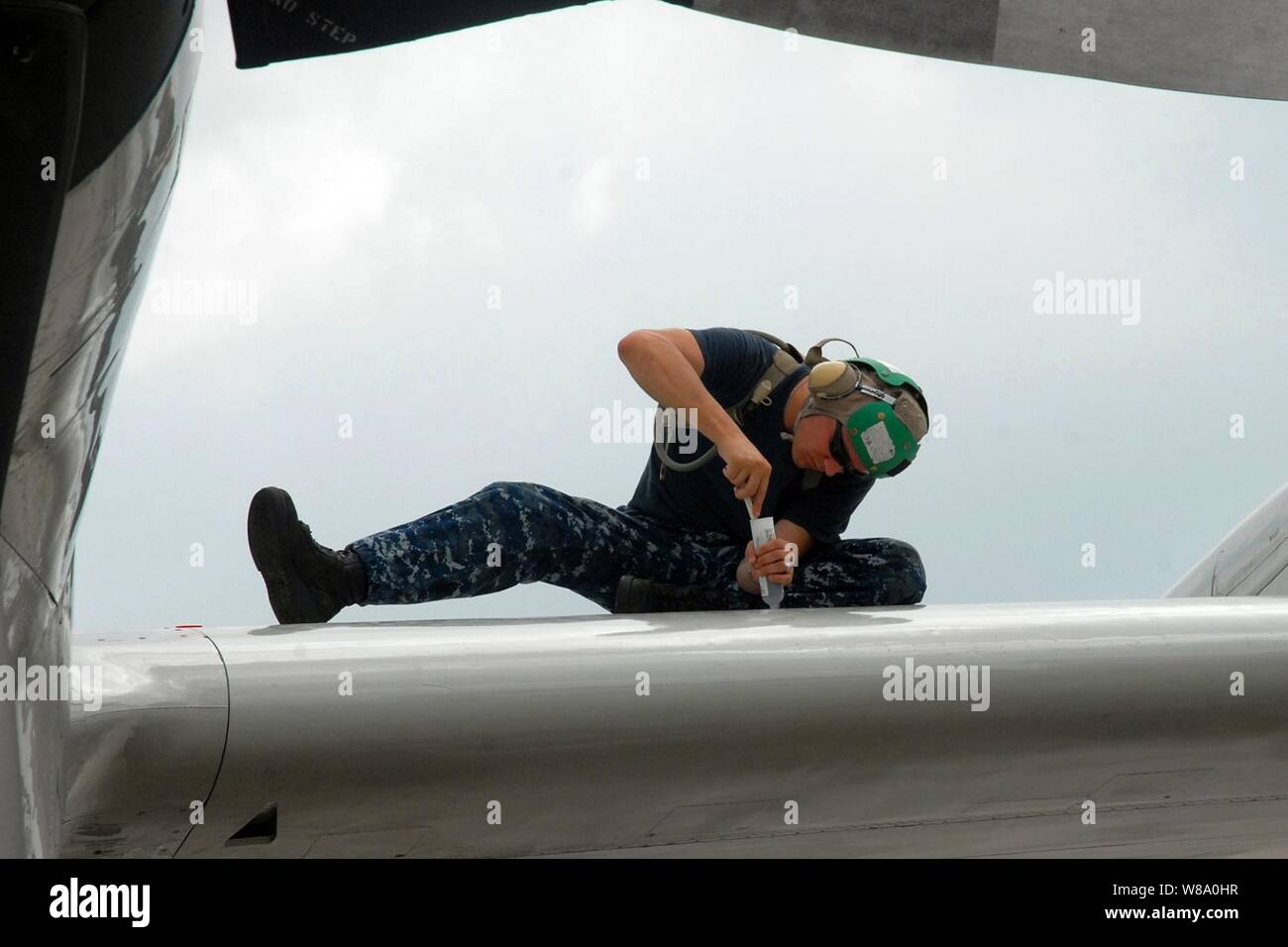 U.S. Navy Petty Officer 2nd Class Ruel Beck applies sealant to a leading edge wing panel of a P-3C Orion on Kadena Air Base in Okinawa, Japan, on Sept. 6, 2011.  Beck is an Aviation Structural Mechanic assigned to Patrol Squadron 40. Stock Photo