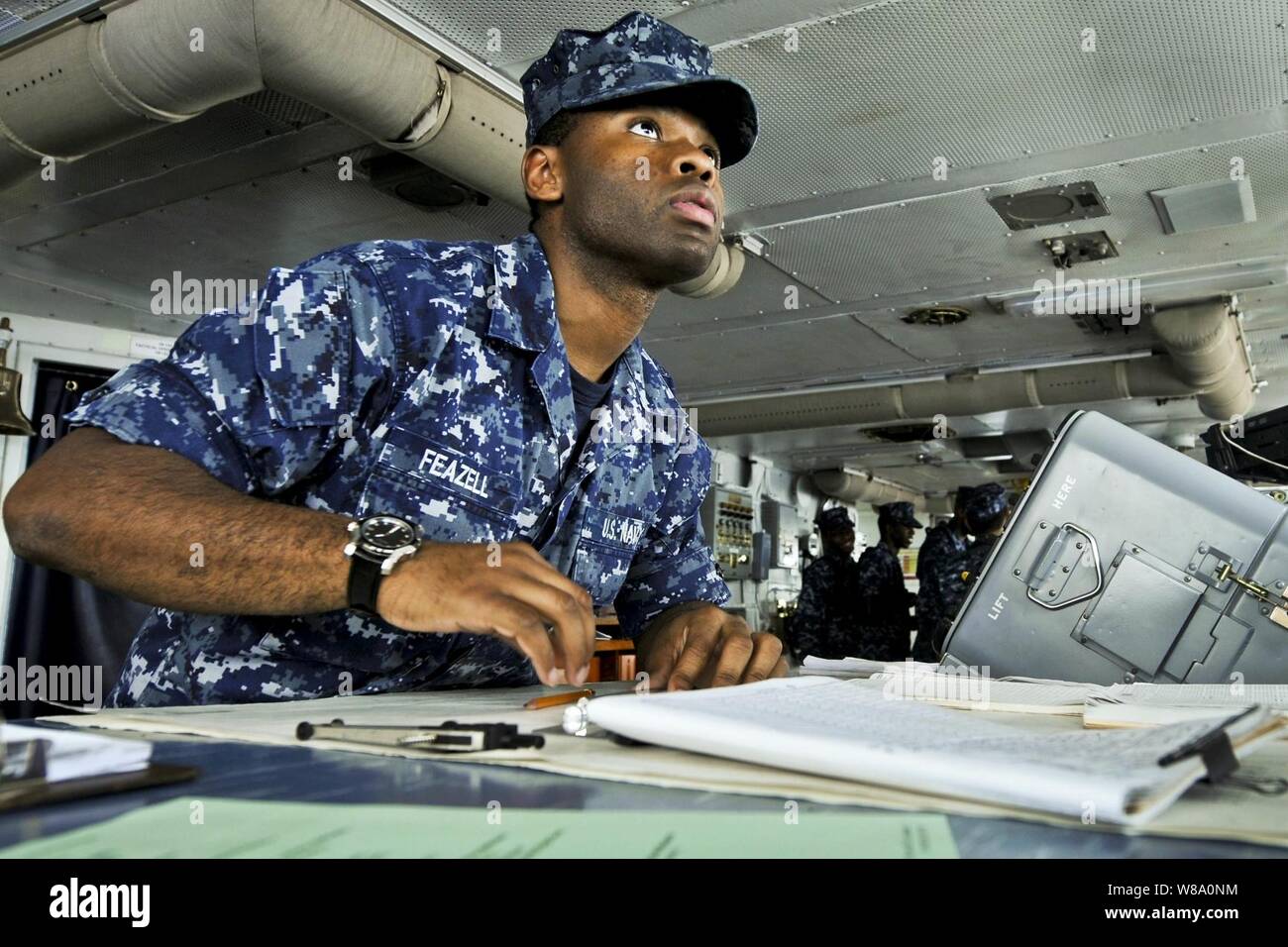 U.S. Navy Seaman Roosevelt Feazell charts a course from the bridge of the aircraft carrier USS Abraham Lincoln in the U.S. 7th Fleet area of responsibility as part of a deployment to the western Pacific and Indian Oceans.  The carrier is en route to support coalition efforts in the U.S. 5th Fleet area of responsibility. Stock Photo