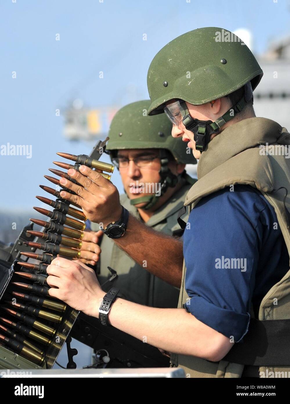 U.S. Navy Petty Officer 1st Class Eduardo Soto (left) instructs Seaman Tyler Bishop on firing a .50 caliber machine gun during a live-fire exercise aboard the U.S. 7th Fleet command ship USS Blue Ridge (LCC 19) in the South China Sea on March 28, 2012. Stock Photo