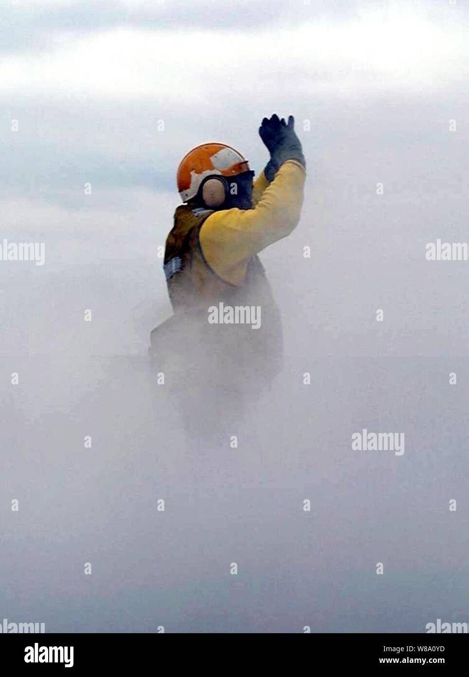 A flight deck handling officer on board the USS Enterprise (CVN 65) is engulfed in steam while directing aircraft onto the number one steam driven catapult during flight operations on April 27, 1996, while the ship is underway for Combined Joint Task Force Exercise '96.  More than 53,000 military service members from the United States and the United Kingdom are participating in Combined Joint Task Force Exercise 96 on military installations in the Southeastern United States and in waters along the Eastern seaboard. Stock Photo