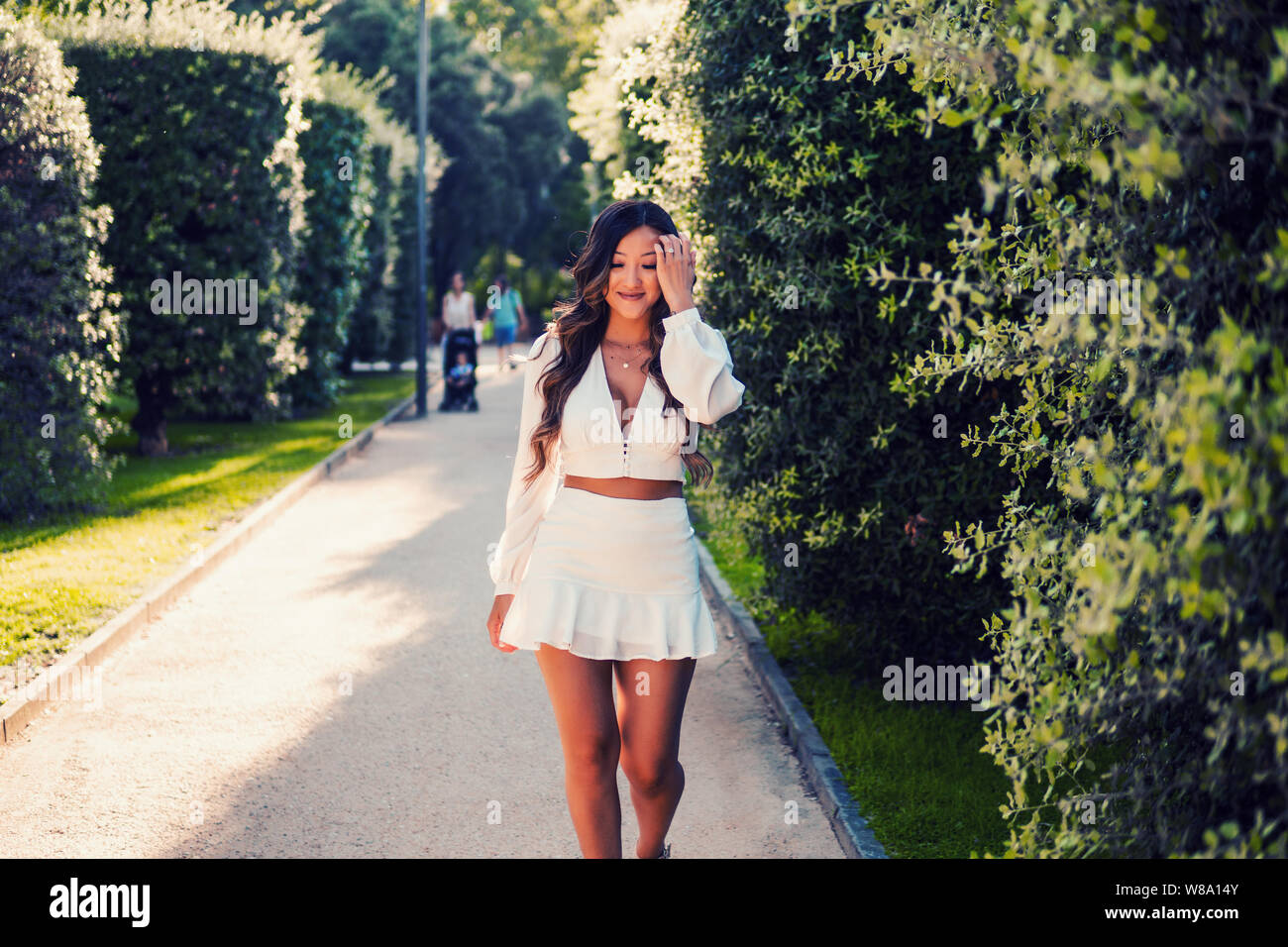 Beautiful Asian girl in white dress smiling in the park Stock Photo - Alamy
