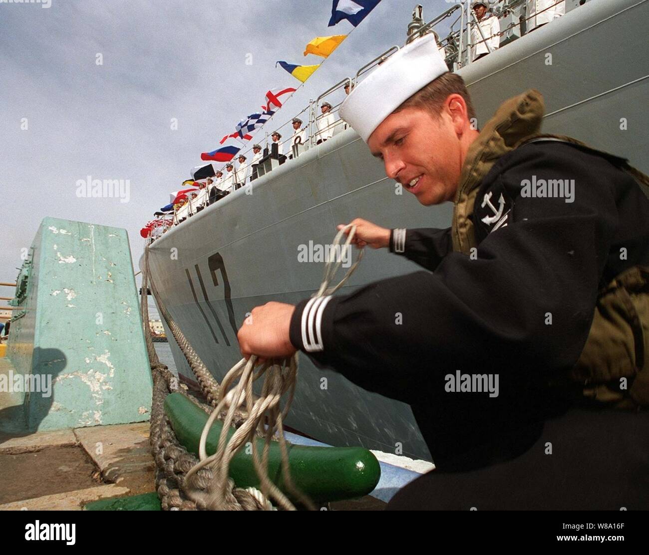 (SAN DIEGO, Calif. MARCH 21, 1997) Seaman Ricardo Ponche lends a hand during line handling party.  Chinese sailors man the decks of the destroyer's HARBIN (DDG 112) as they arrive pier side of Naval Air Station North Island at San Diego as a goodwill gesture between the U. S. and Chinese navies.  This marks the first time Chinese warships have crossed the Pacific and visited the Continental United States.  The destroyers Harbin and Zhuhai, and supply ship Nancang will moor next to the U. S. Navy's aircraft carrier USS Constellation (CV 64), at Naval Station, North Island.  The ships are expect Stock Photo