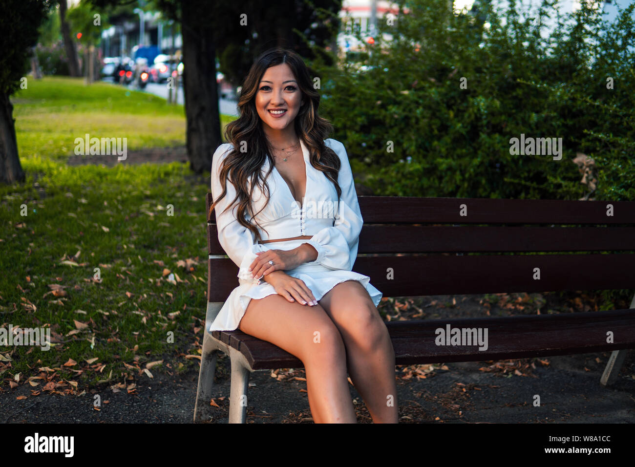 Beautiful Asian girl in white dress smiling in the park Stock Photo - Alamy