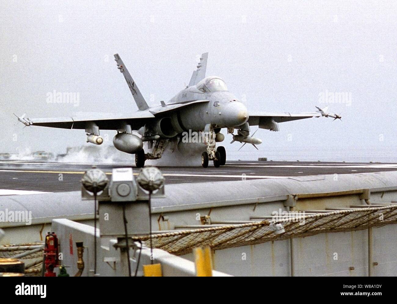 An F/A-18C Hornet launches from the waist catapult during flight operations on board the aircraft carrier USS Nimitz (CVN 68) in the Persian Gulf on Nov. 11, 1997.  The Nimitz and embarked Carrier Air Wing 9 are operating in the Persian Gulf in support of the U.S. and coalition enforcement of the no-fly-zone over Southern Iraq.  The Hornet is armed with AIM-9 Sidewinder heat-seeking, short-range air-to-air missiles, RIM-7M Sea Sparrow radar-guided air-to-air missiles, Rockeye cluster bombs, and the AGM-88 High Speed Anti-Radiation missile (HARM), used as an air-to-ground weapon to seek out and Stock Photo
