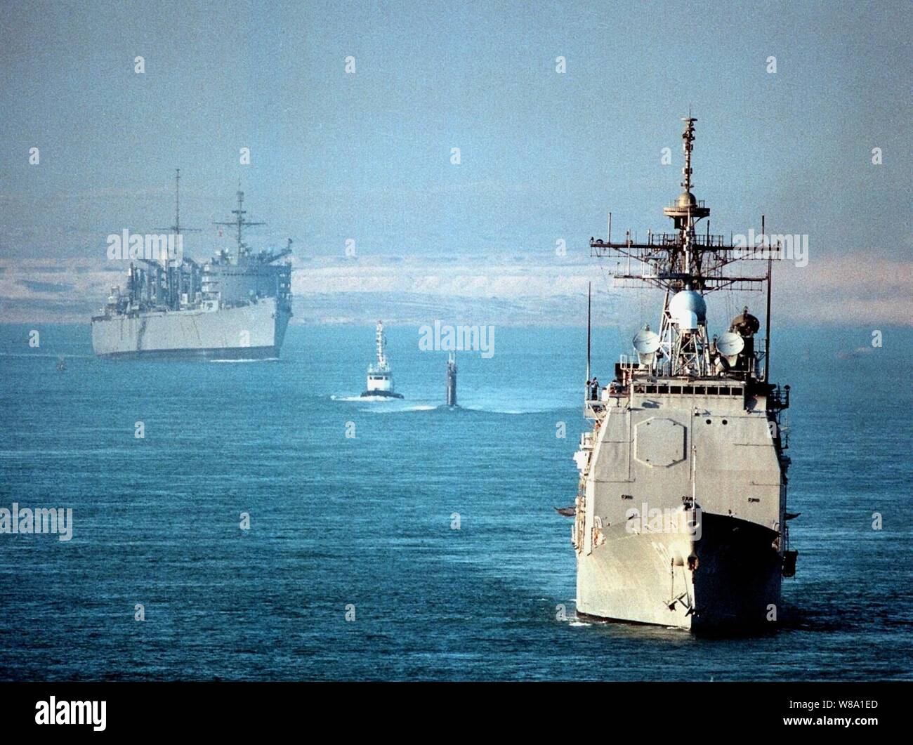 The USS Normandy (CG 60) (right), the fast attack submarine USS Annapolis (SSN 760) (center), and the fast combat support ship USS Seattle (AOE 3) (left) transit the Suez Canal on Nov. 16, 1997, as they head from the Mediterranean Sea to the Persian Gulf.  The three U.S. ships are part of the aircraft carrier USS George Washington (CVN 73) battle group which has been ordered to the Persian Gulf to join the aircraft carrier USS Nimitz (CVN 68) battle group already on station.  The two battle groups will be operating in the Persian Gulf in support of Operation Southern Watch which is the U.S. an Stock Photo