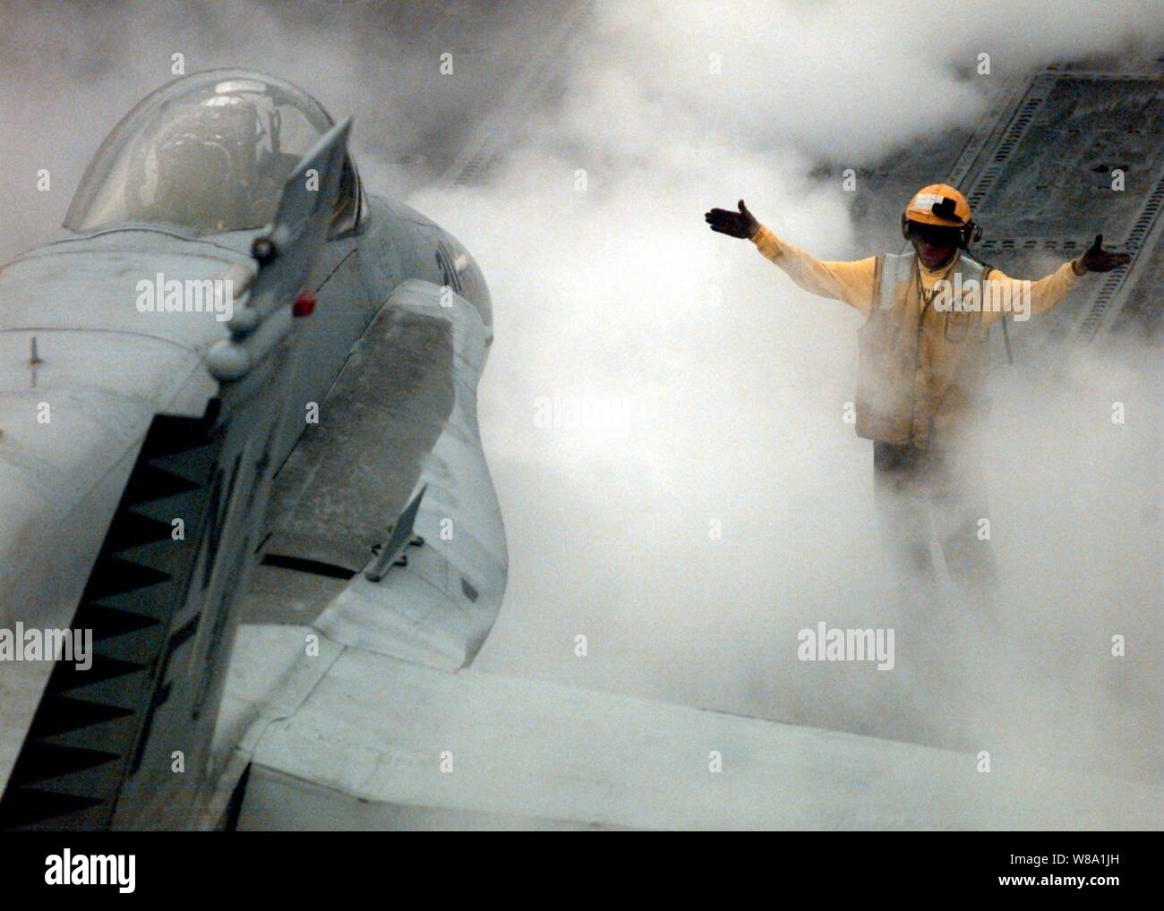 A flight deck handler aboard the aircraft carrier USS Independence (CV 62) is engulfed in steam as he directs an F/A-18 Hornet to the catapult for launch while the ship operates in the Persian Gulf on Feb. 11, 1998.  Independence and its embarked Carrier Air Wing 5 are on station in the Persian Gulf in support of Operation Southern Watch which is the U.S. and coalition enforcement of the no-fly-zone over Southern Iraq. Stock Photo