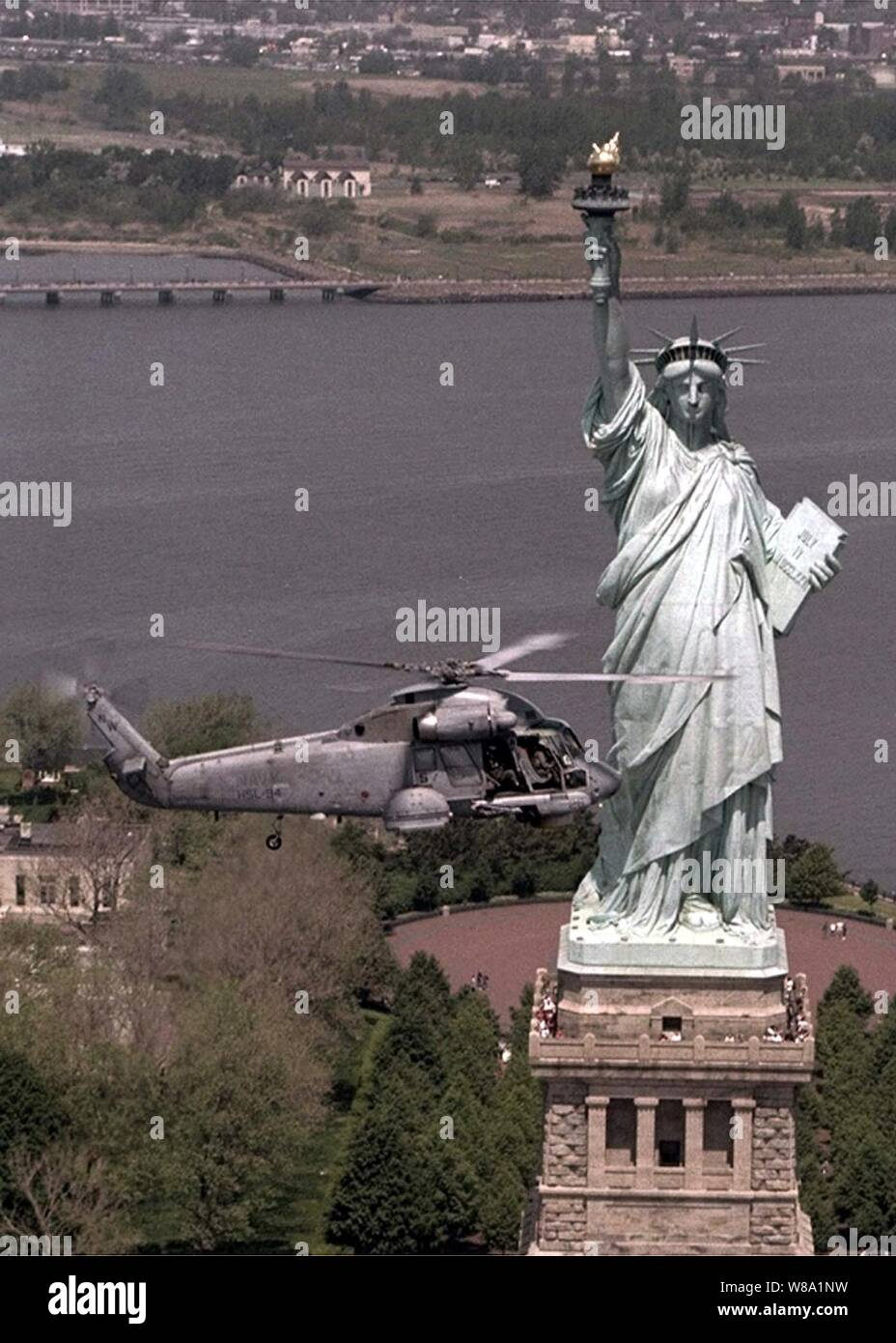 A U.S. Navy SH-2 Seasprite helicopter flies by the Statue of Liberty during the opening ceremonies of Fleet Week '98 in New York on May 20, 1998.  The Seasprite is a ship based helicopter with anti-submarine and anti-ship surveillance and targeting capabilities.  The Seasprite is from Light Helicopter Anti-Submarine Squadron 94, Naval Air Station Willow Grove, Pa. Stock Photo