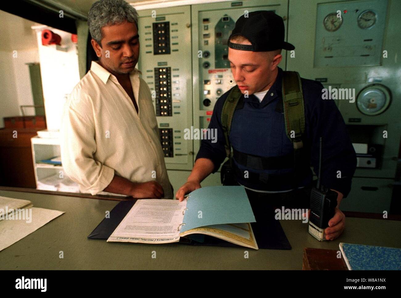 Lt. j.g. Vincent C. Watson (right) talks to the master (left) of an Iranian cargo ship as he inspects the shipХs documents during a maritime interdiction operation in the Persian Gulf on March 6, 1998.  Crew members from the USS John S. McCain (DDG-56) boarded and are inspecting the ship for possible contraband.  The Arleigh Burke class destroyer is conducting the interception operations as part of a force augmentation in the region. The McCain is home ported in Yokosuka, Japan. Stock Photo