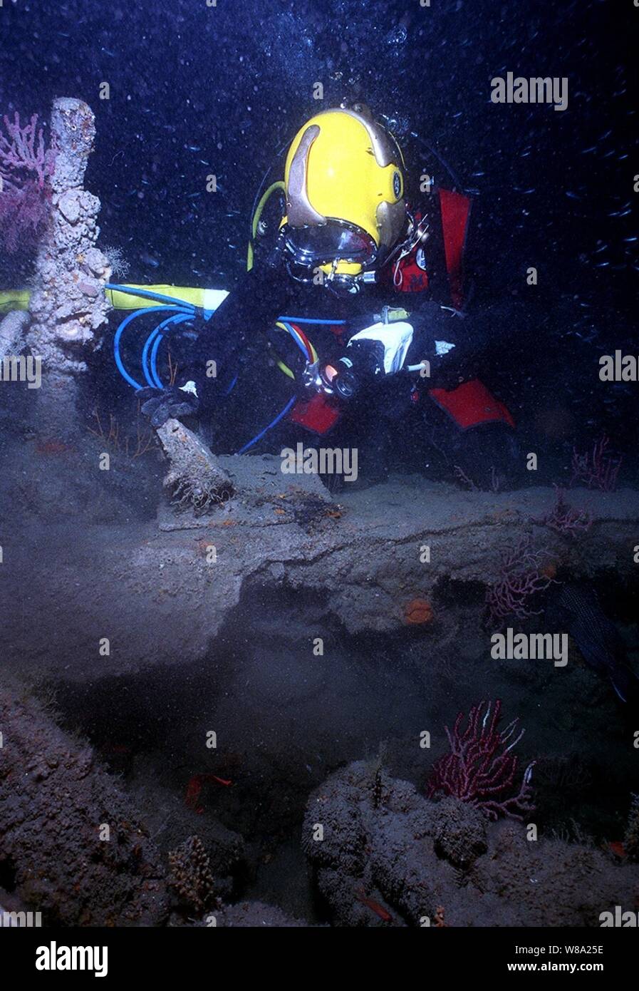U.S. Navy Cmdr. Philip G. Beierl inspects an artifact on the sunken U.S. Civil War ship USS Monitor 240 feet below the oceanХs surface on June 23, 1999.  Beierl is diving from the USS Grasp (ARS 51) in waters sixteen miles off Cape Hatteras, N.C.  The battle between the USS Monitor and the CSS Virginia, formerly the USS Merrimack, on March 9, 1862, at Hampton Roads, Va., was the first battle fought by iron armored vessels during the civil war.  Beierl is the commanding officer of Mobile Diving and Salvage Unit Two. Stock Photo
