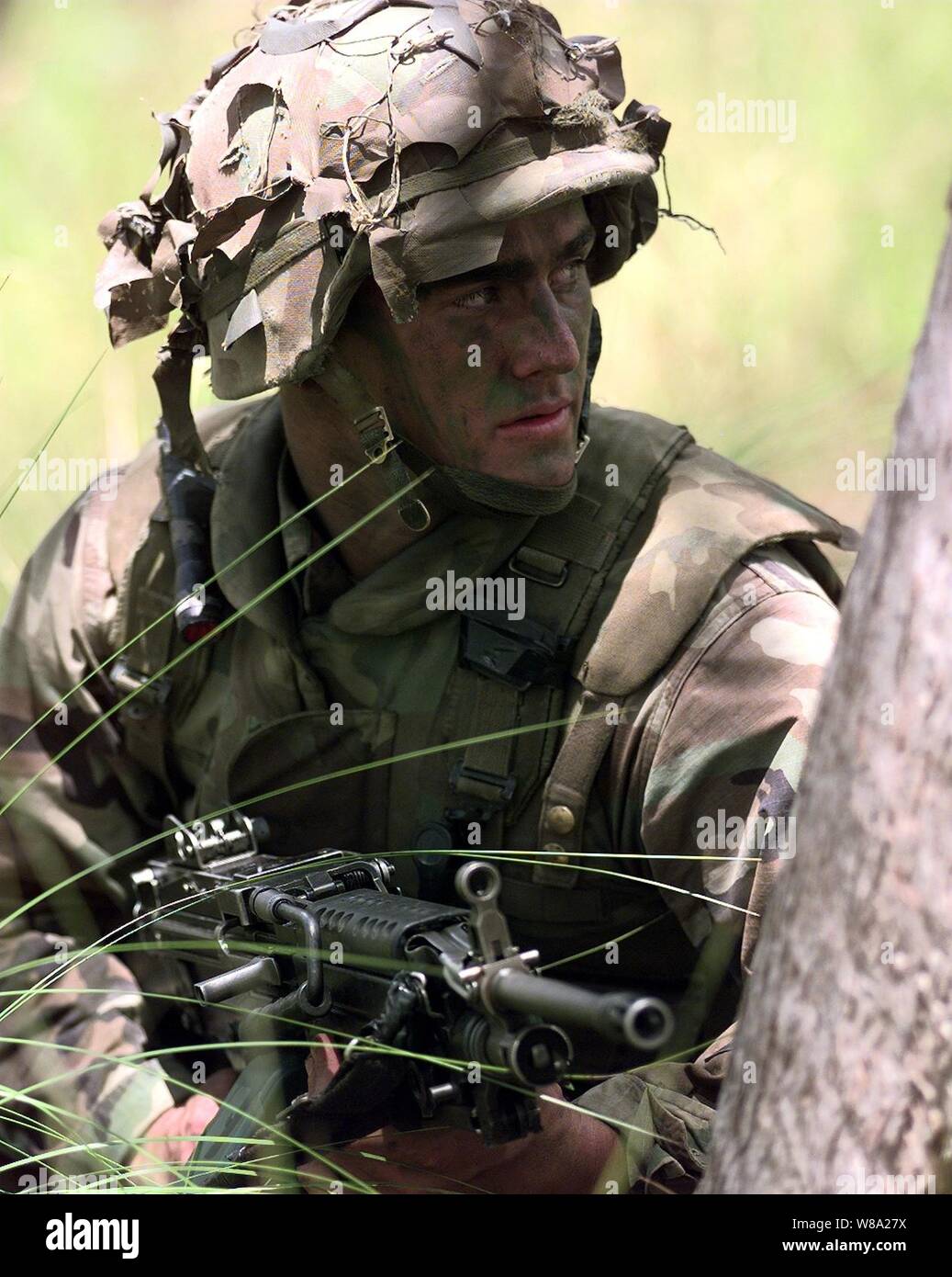 Pfc. Joe Gould, U.S. Marine Corps, looks for aggressor targets during a live fire exercise at the Shoalwater Bay Training Area in Queensland, Australia, on Oct. 3, 1999, as part of Exercise Crocodile '99.  Exercise Crocodile '99 is a combined U.S. and Australian military training exercise.  Gould is attached to Battalion Landing Team 15, Bravo Company. Stock Photo