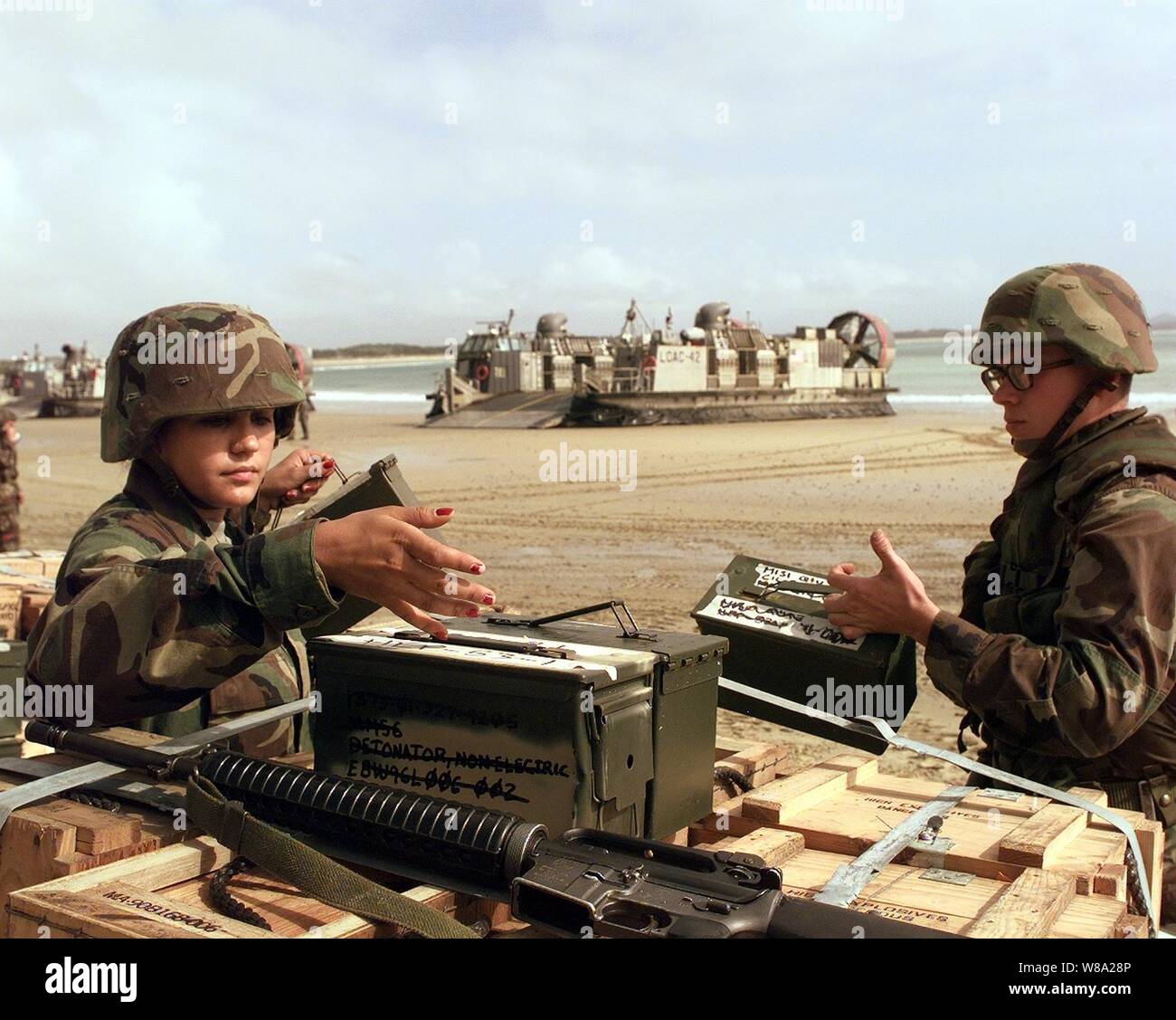 U.S. Marine Pfc. Reuschel Ortiz (left) directs the redistribution of ammunition at Freshwater Beach, Australia, during amphibious assault landing operations of Exercise Crocodile '99 on Oct. 1, 1999.  Exercise Crocodile '99 is a combined U.S. and Australian military training exercise being conducted at the Shoalwater Bay Training Area in Queensland, Australia. Stock Photo