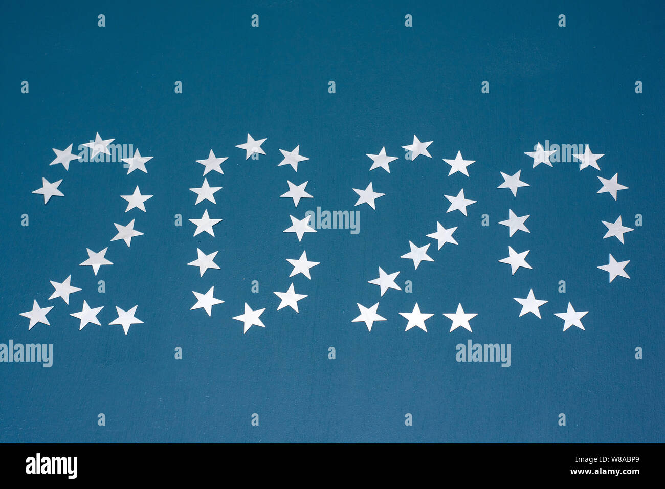 Happy New Year 2020. The emblem of the new 2020. Figures laid out with confetti on a blue background. Stock Photo