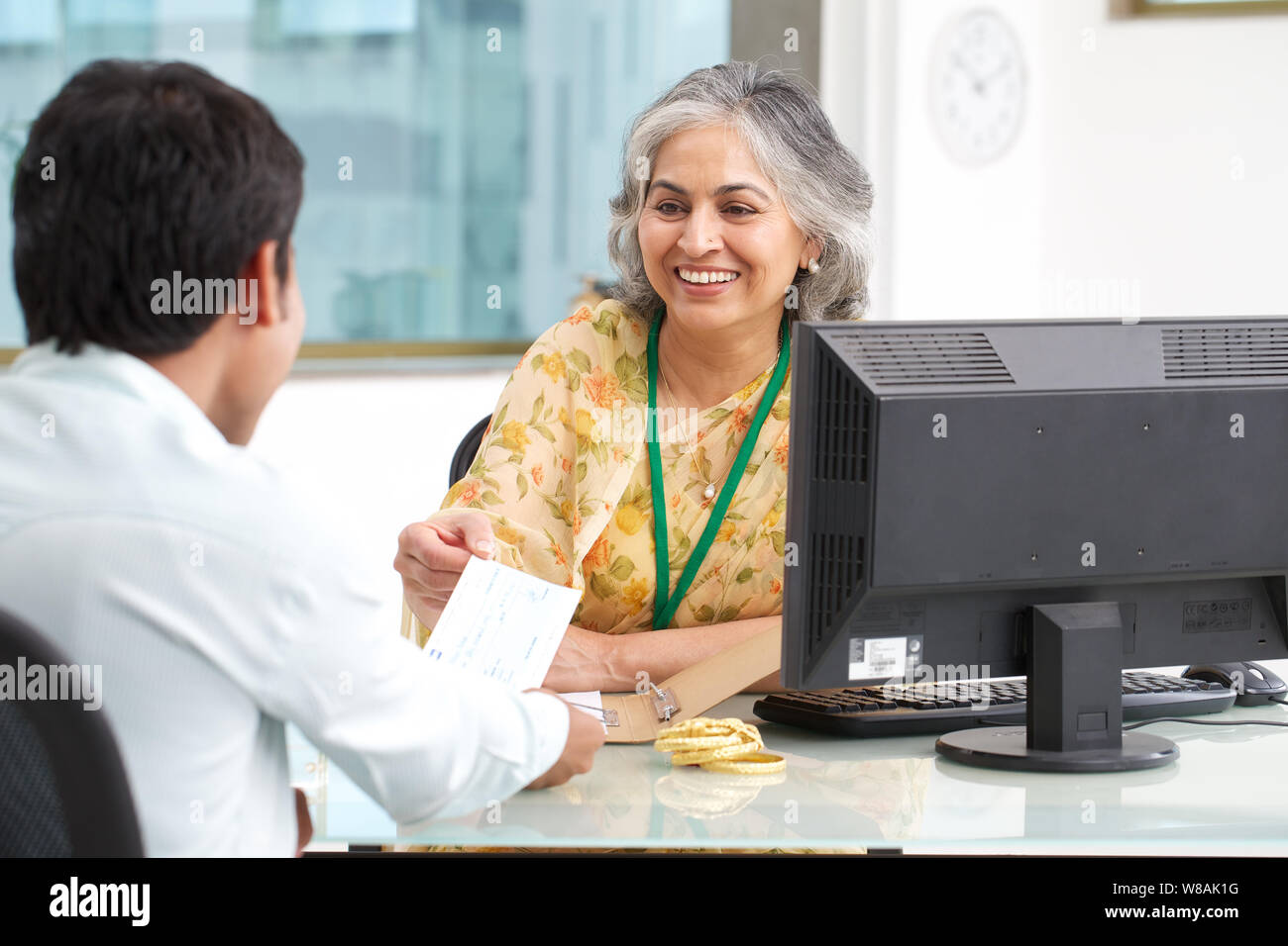 Bank manager giving cheque to her customer as gold loan Stock Photo - Alamy