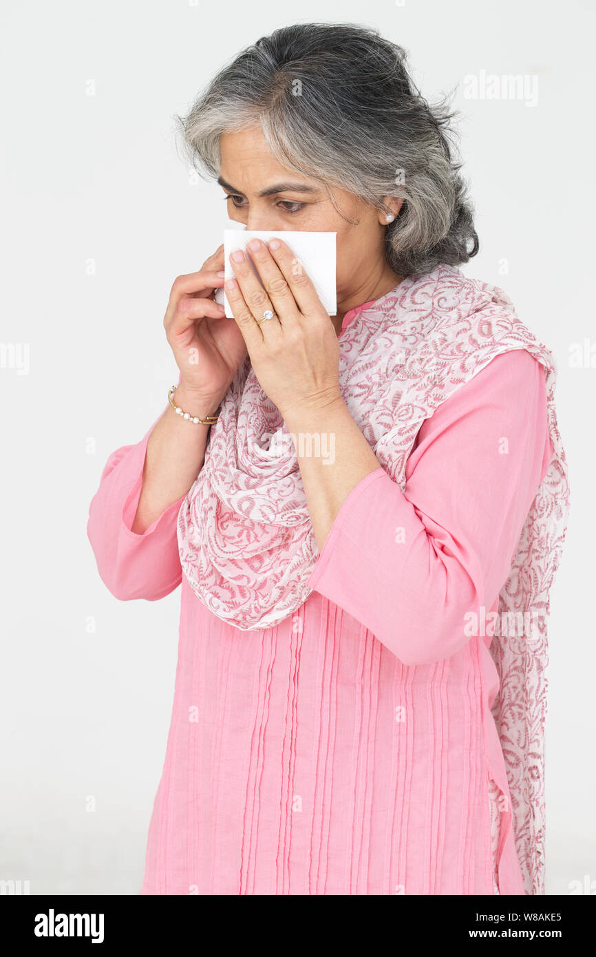 Senior woman blowing nose with handkerchief Stock Photo Alamy