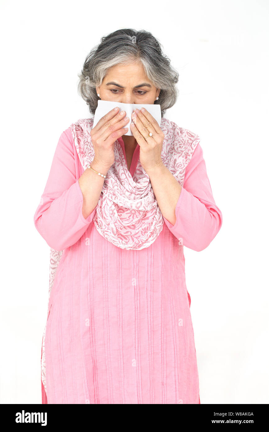 Senior woman blowing nose with handkerchief Stock Photo Alamy