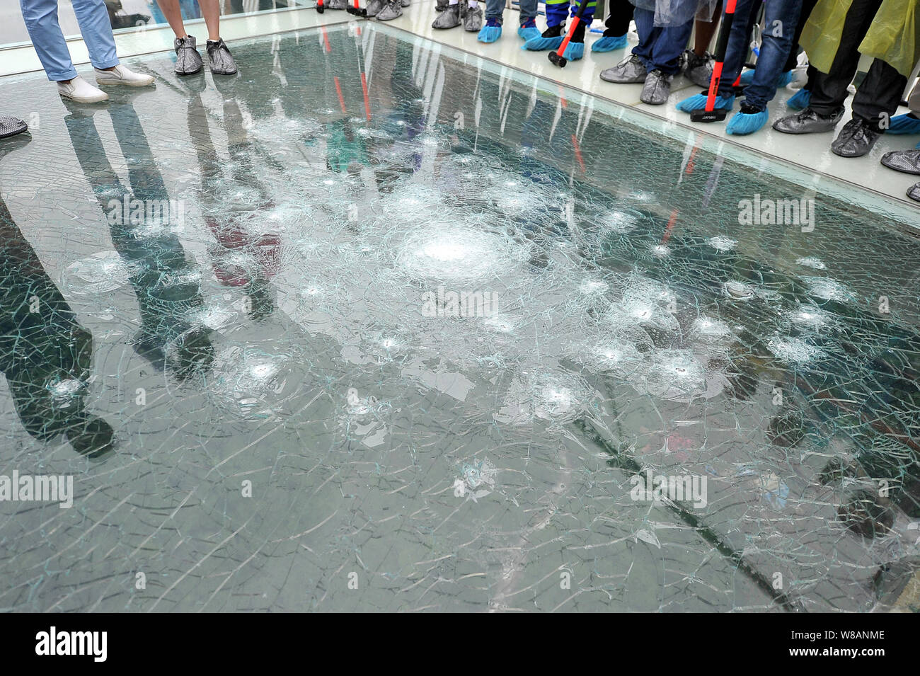 Chinese visitors look at the cracked glass smashed by them during a safety  test on the world's longest and highest glass-bottomed bridge over the Zhan  Stock Photo - Alamy