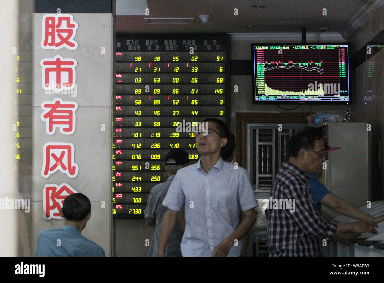 Chinese investors look at prices of shares (green for price falling) at a stock brokerage house in Nanjing city, east China's Jiangsu province, 13 Jun Stock Photo