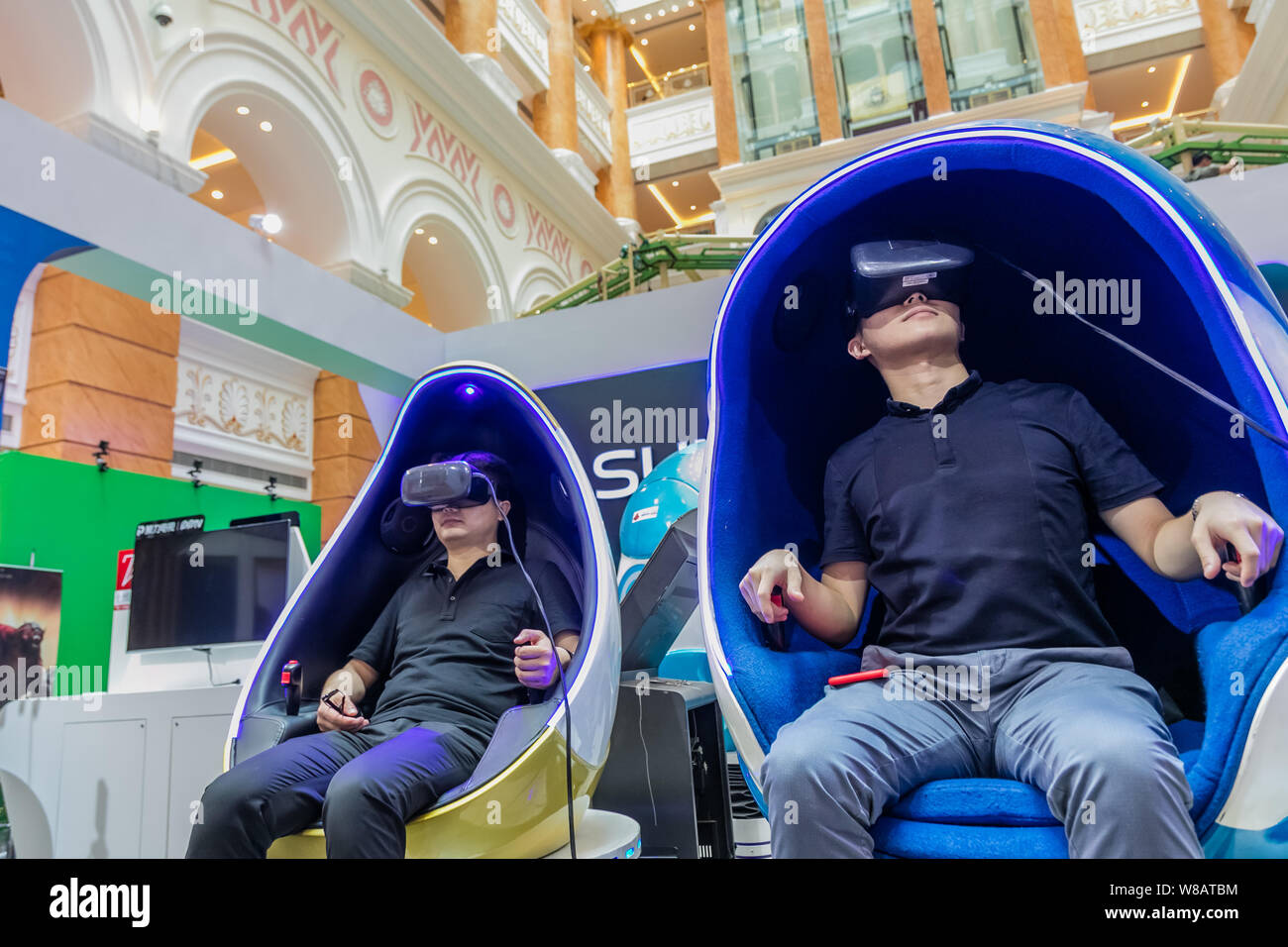 Chinese visitors try out VR (Virtual Reality) devices during an