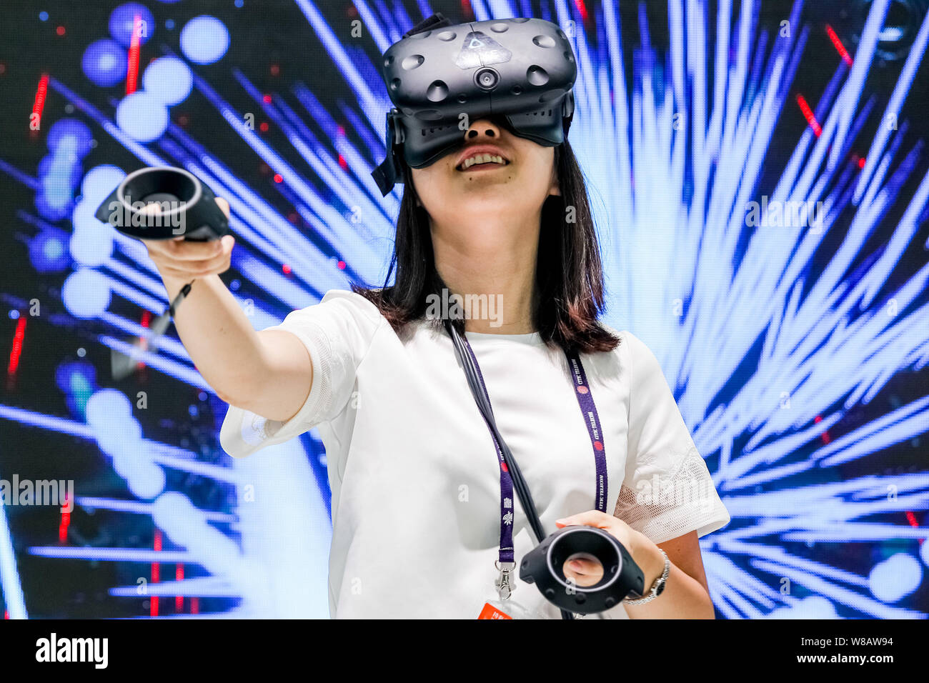 A visitor tries out an HTC VR (Virtual Reality) device during the 2016 Mobile World Congress (MWC) in Shanghai, China, 29 June 2016.   The Mobile Worl Stock Photo