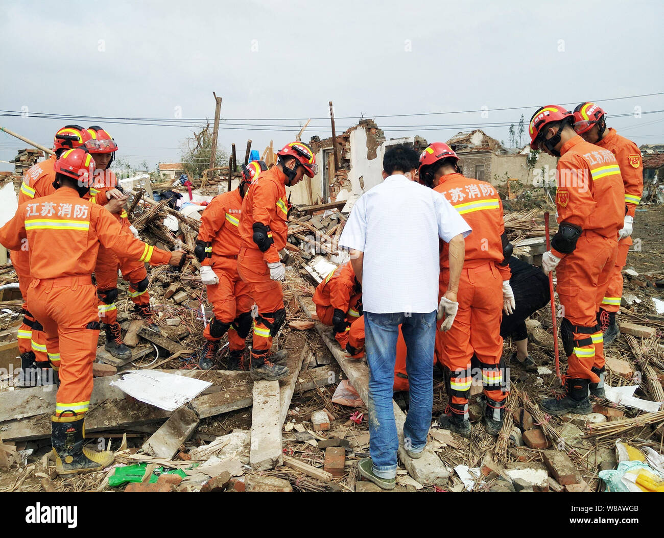 Chinese rescuers search for victims and survivors in the rubble of collapsed houses blown down by the massive tornado in Jiqiao village, Funing county Stock Photo