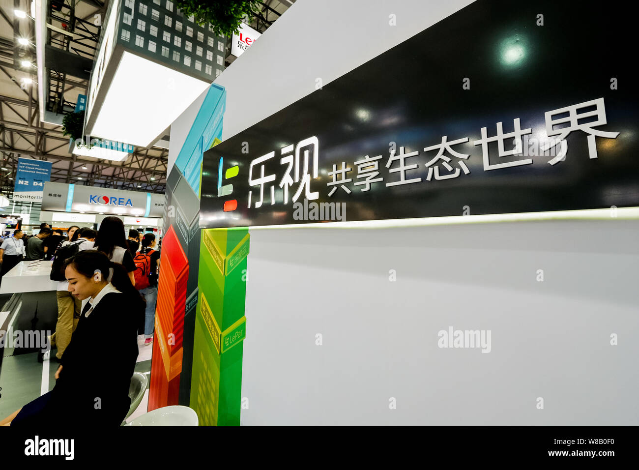 Chinese employees are seen at the stand of LeEco, formerly called Letv or Leshi, during the 2016 Mobile World Congress (MWC) in Shanghai, China, 29 Ju Stock Photo