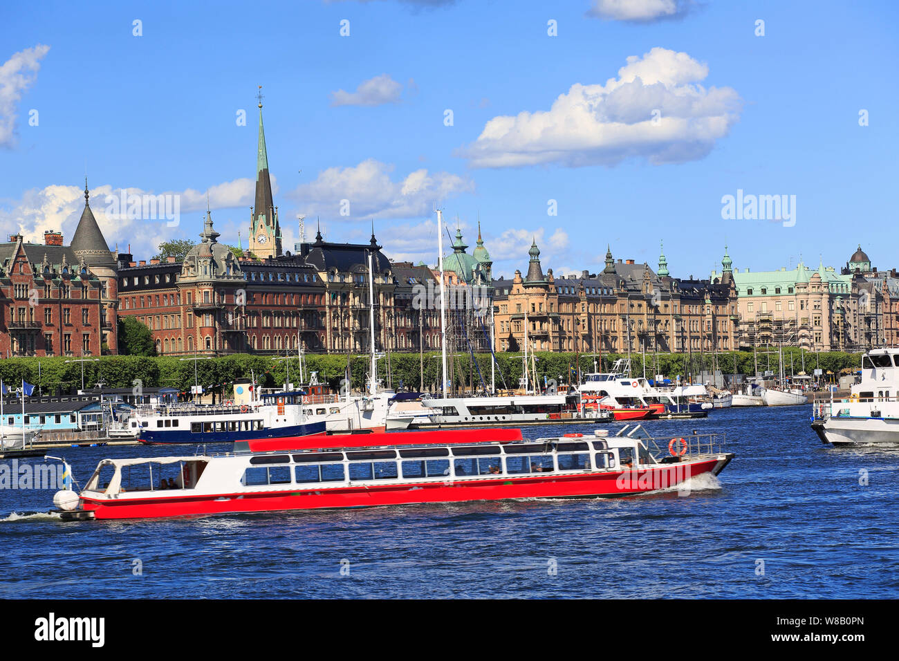 Scenic view of Stockholm's skyline and harbor, with a red passenger boat on the foreground, Sweden Stock Photo