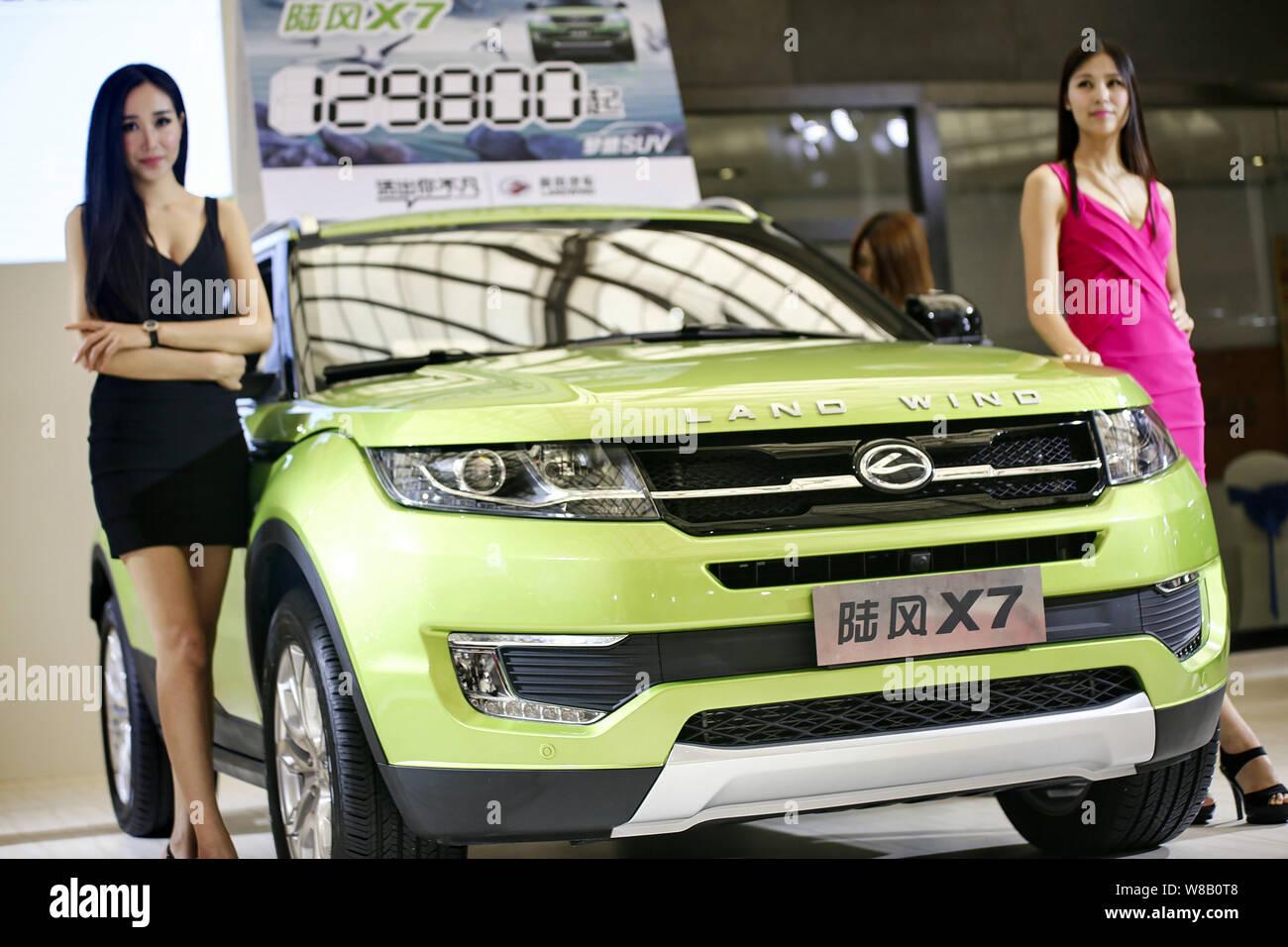 --FILE--Models pose with a Landwind X7 SUV of JMC (Jiangling Motor Co.), which resembles the Range Rover Evoque of Jaguar Land Rover, during an auto s Stock Photo