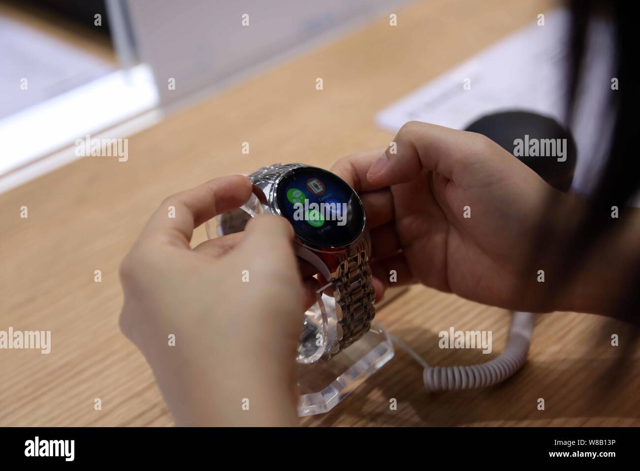 A visitor tries out a smart watch of ZTE during the 2016 Mobile World Congress (MWC) in Shanghai, China, 29 June 2016.   The Mobile World Congress (MW Stock Photo