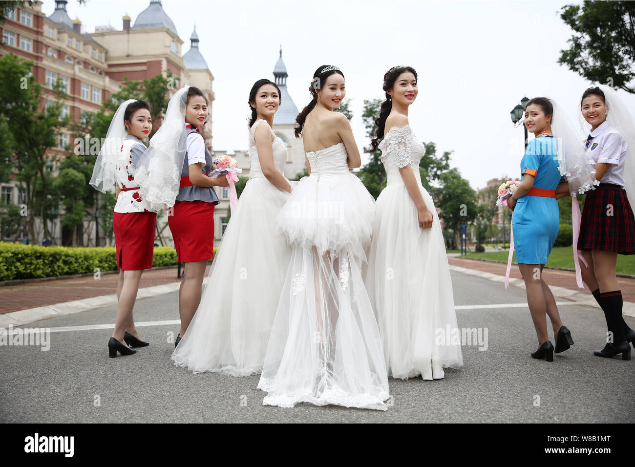 Female Chinese Graduates Dressed In Wedding Gowns Pose For Their