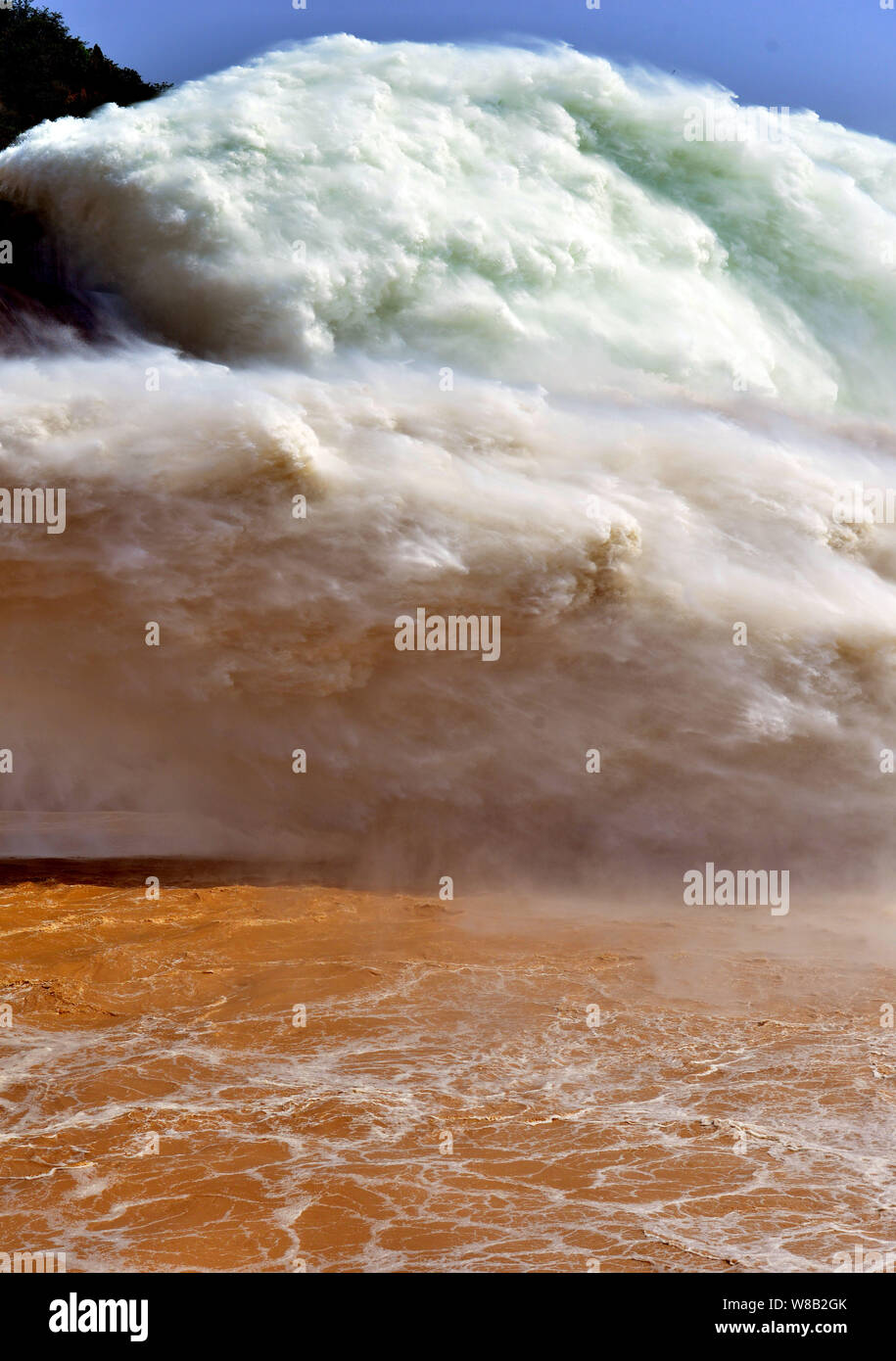 Silt-laden water rushing over a weir on the River Stour Blandford Dorset  England UK Stock Photo - Alamy